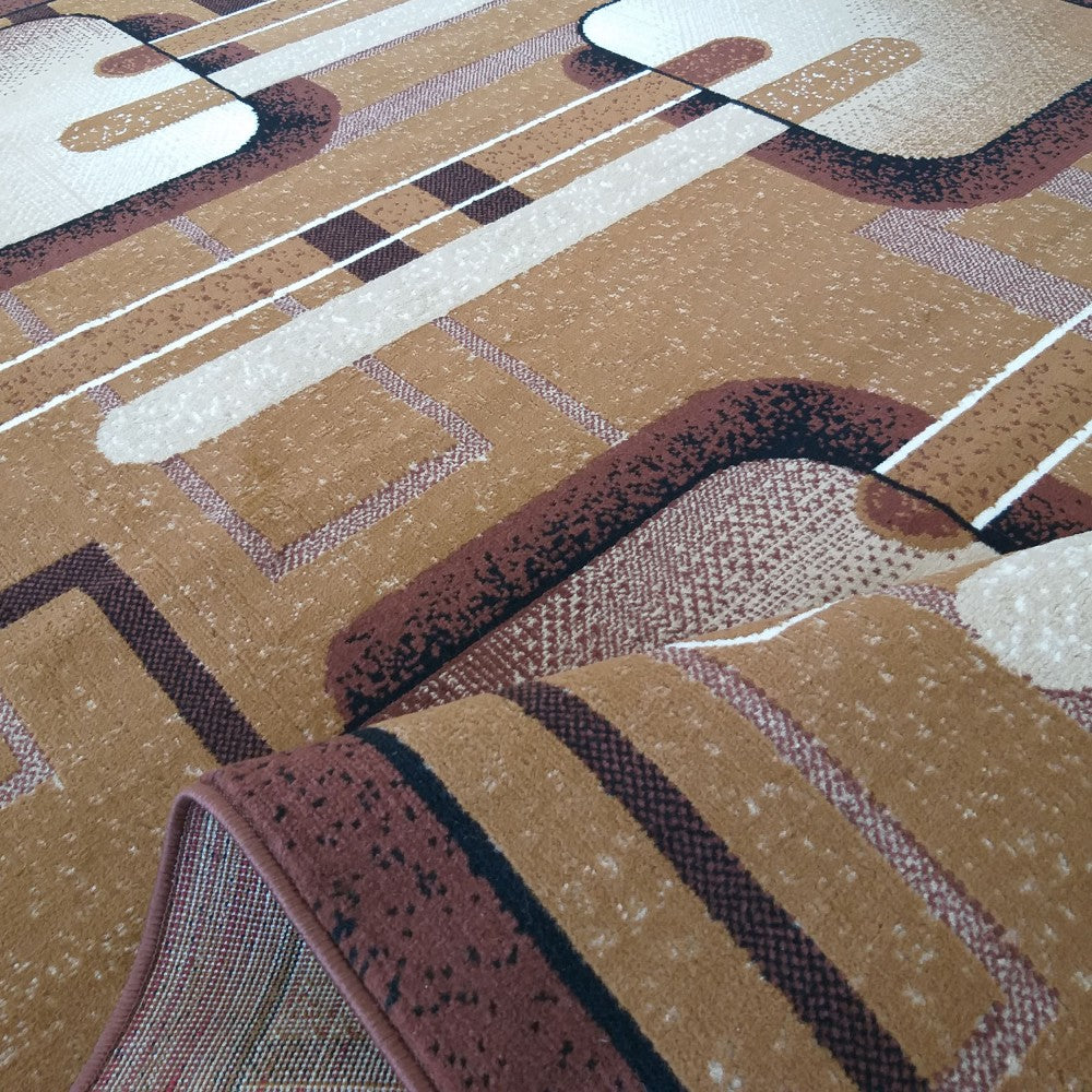 Tapis à motifs abstraits géométriques aux couleurs chaudes de marron, beige et noir, avec une partie de la bordure légèrement roulée