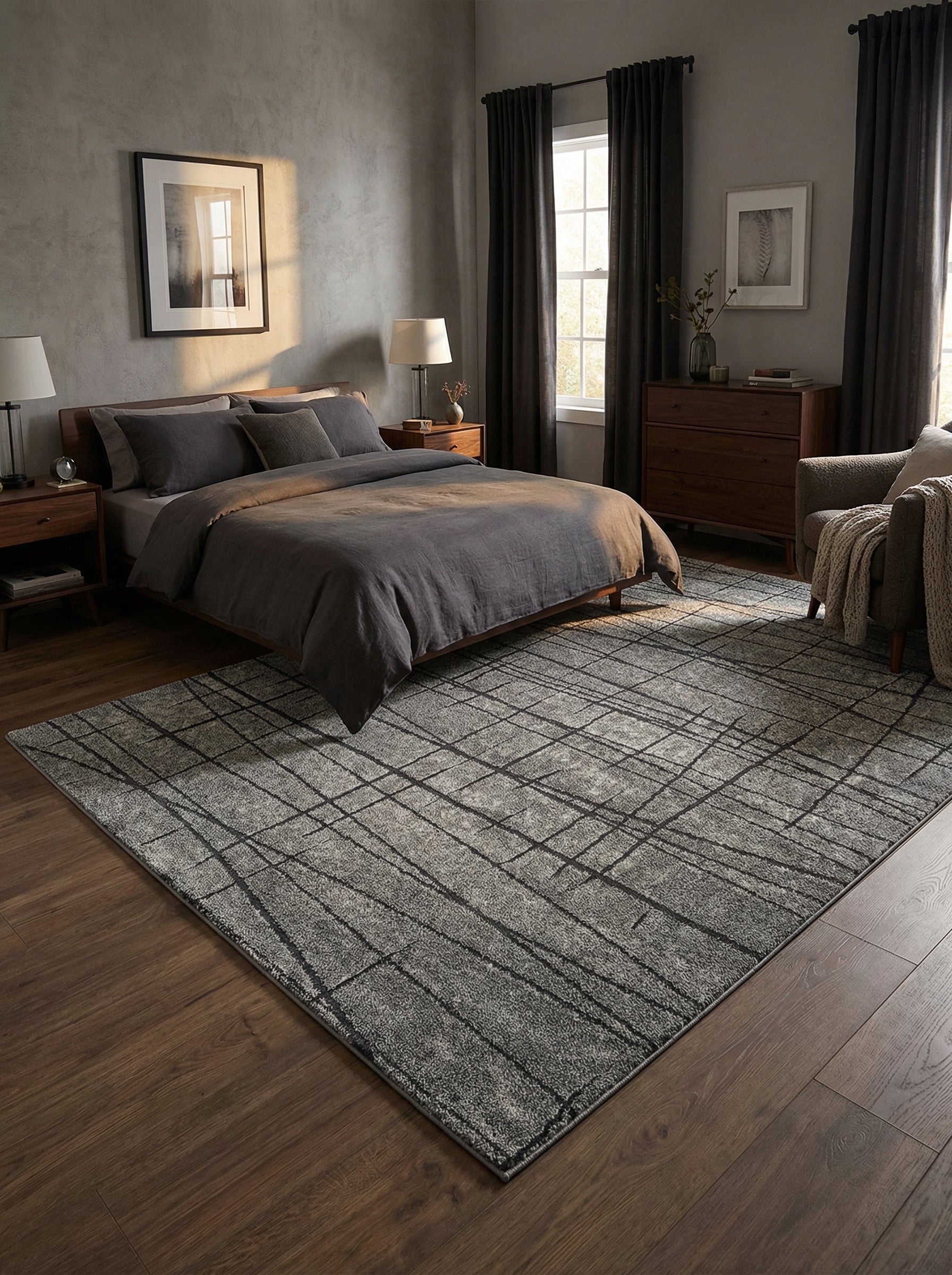 Tapis rectangulaire gris chiné à motifs de lignes entrelacées foncées et irrégulières, posé sur un parquet dans une chambre
