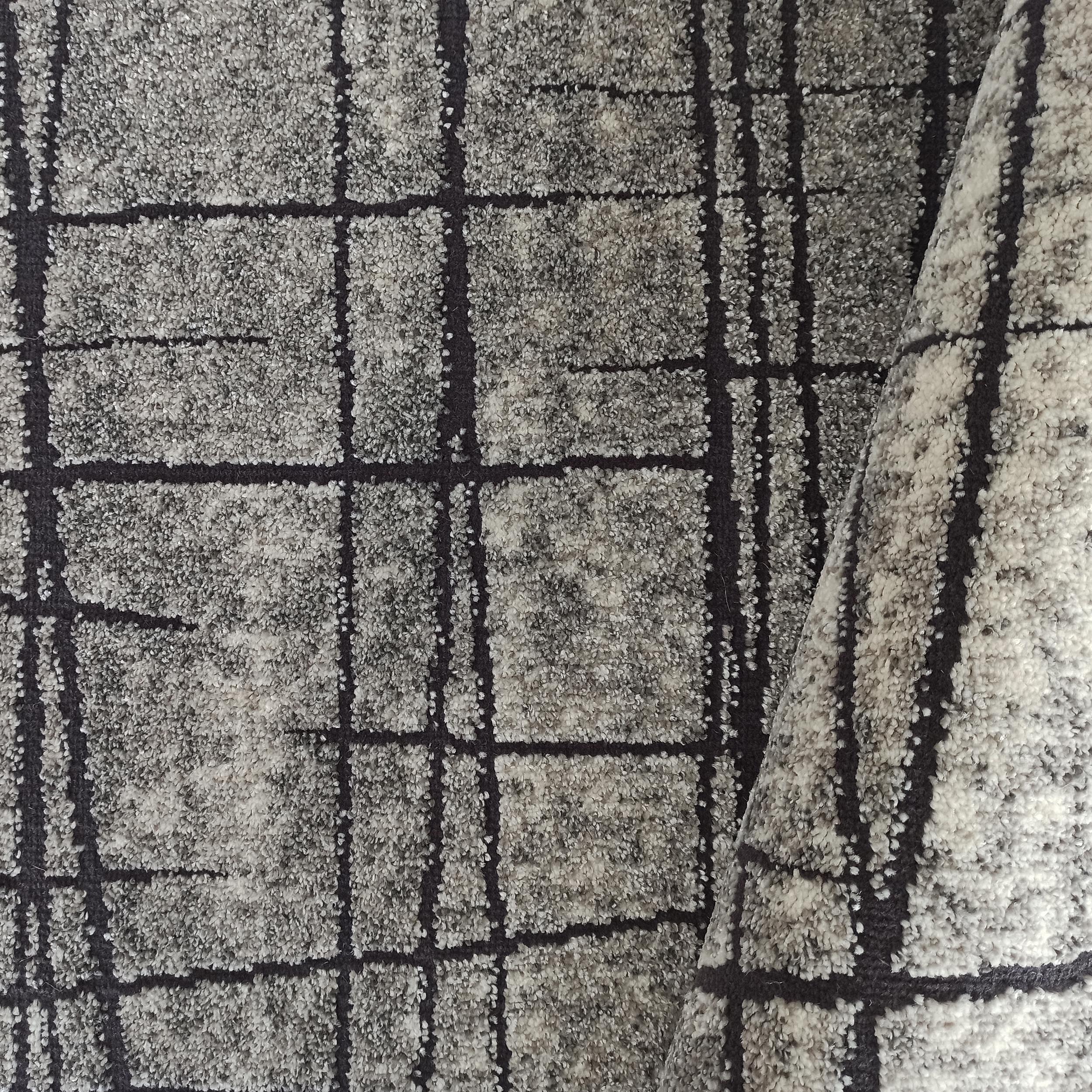 Tapis à texture mouchetée gris clair et gris foncé, avec un motif de lignes sombres irrégulières