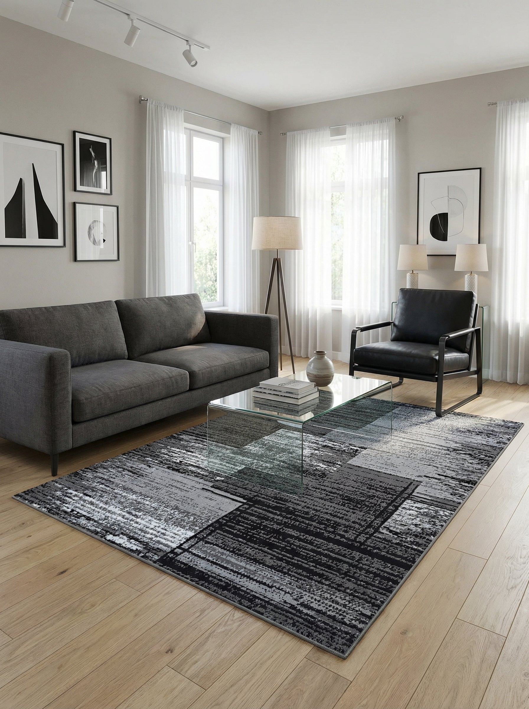 Tapis rectangulaire à motifs abstraits en dégradé de noir, gris et blanc, posé sur un parquet clair dans un salon moderne