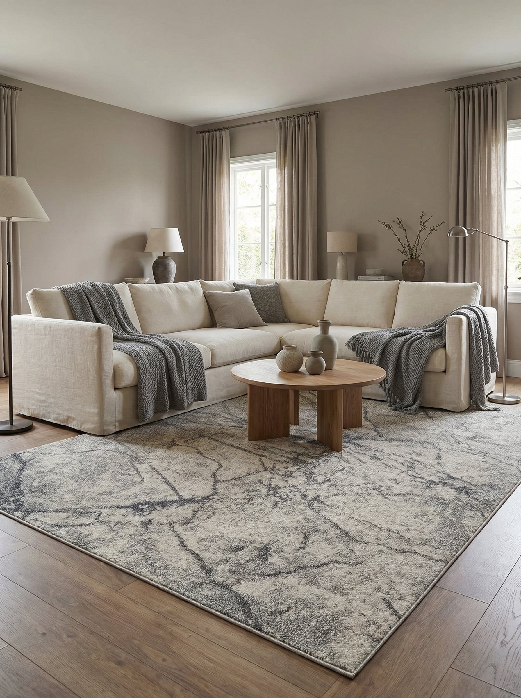 Tapis rectangulaire texturé gris clair et anthracite aux motifs abstraits évoquant des marbrures dans un salon
