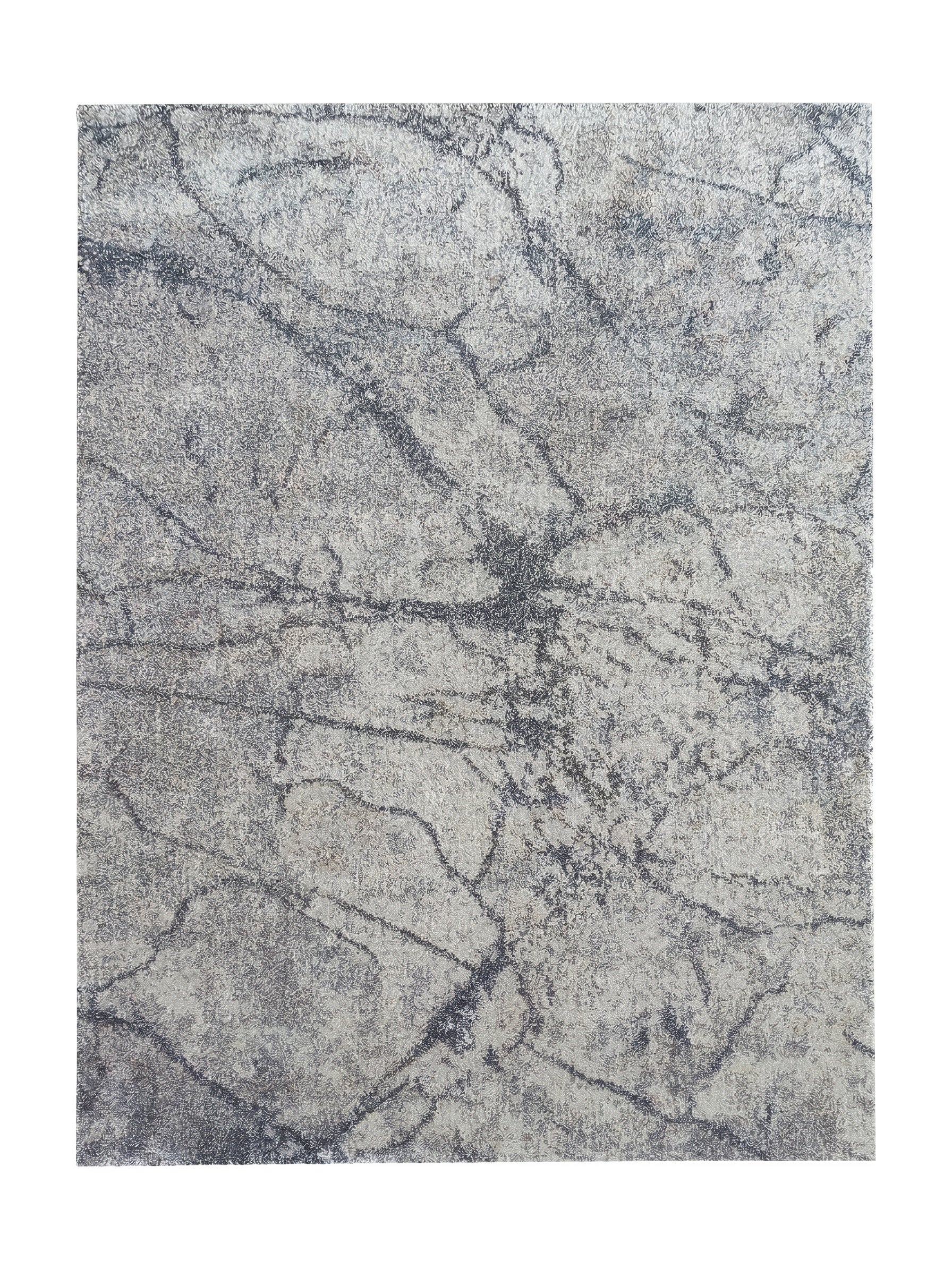 Tapis moelleux aux teintes de gris claires et foncées, avec un motif abstrait marbré et texturé