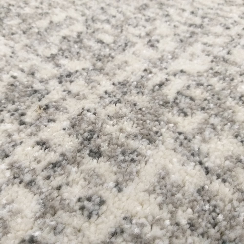 Tapis en gros plan avec une texture épaisse et un motif irrégulier de gris clair et de gris anthracite