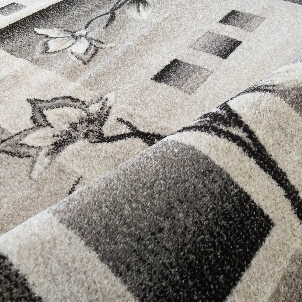 Tapis moelleux aux motifs floraux et géométriques en dégradés de gris, blanc cassé et noir, partiellement roulé