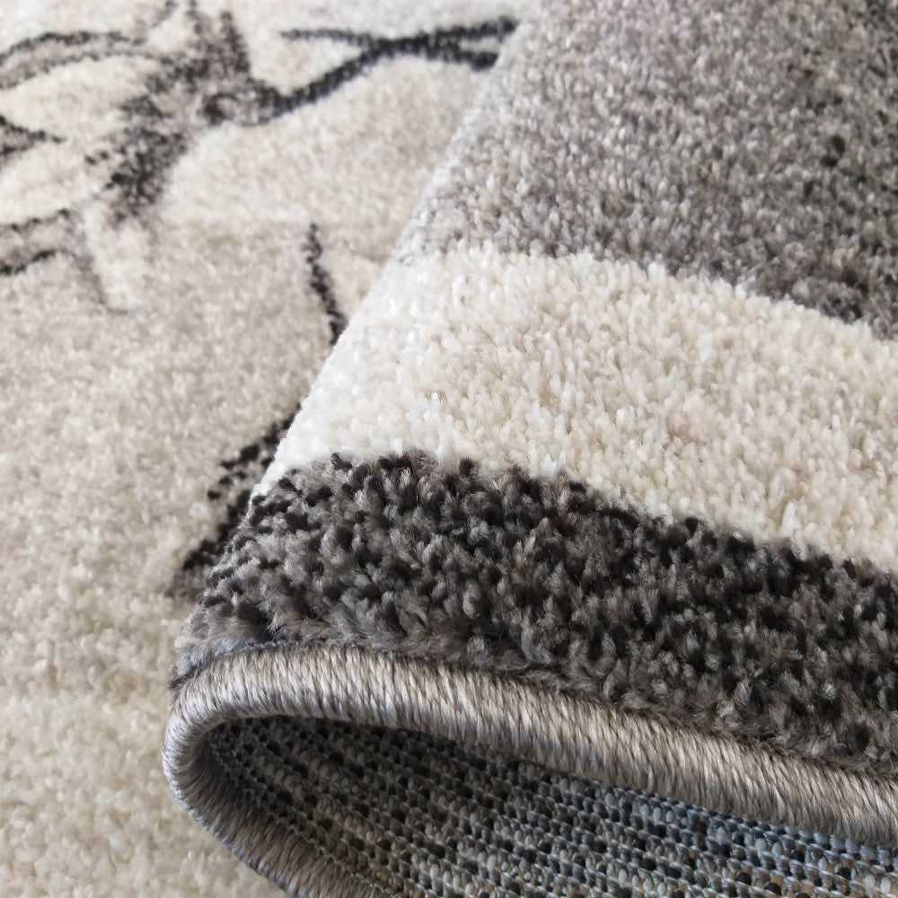 Tapis à poils longs aux motifs floraux abstraits gris et crème, avec une bordure rayée et un revers texturé