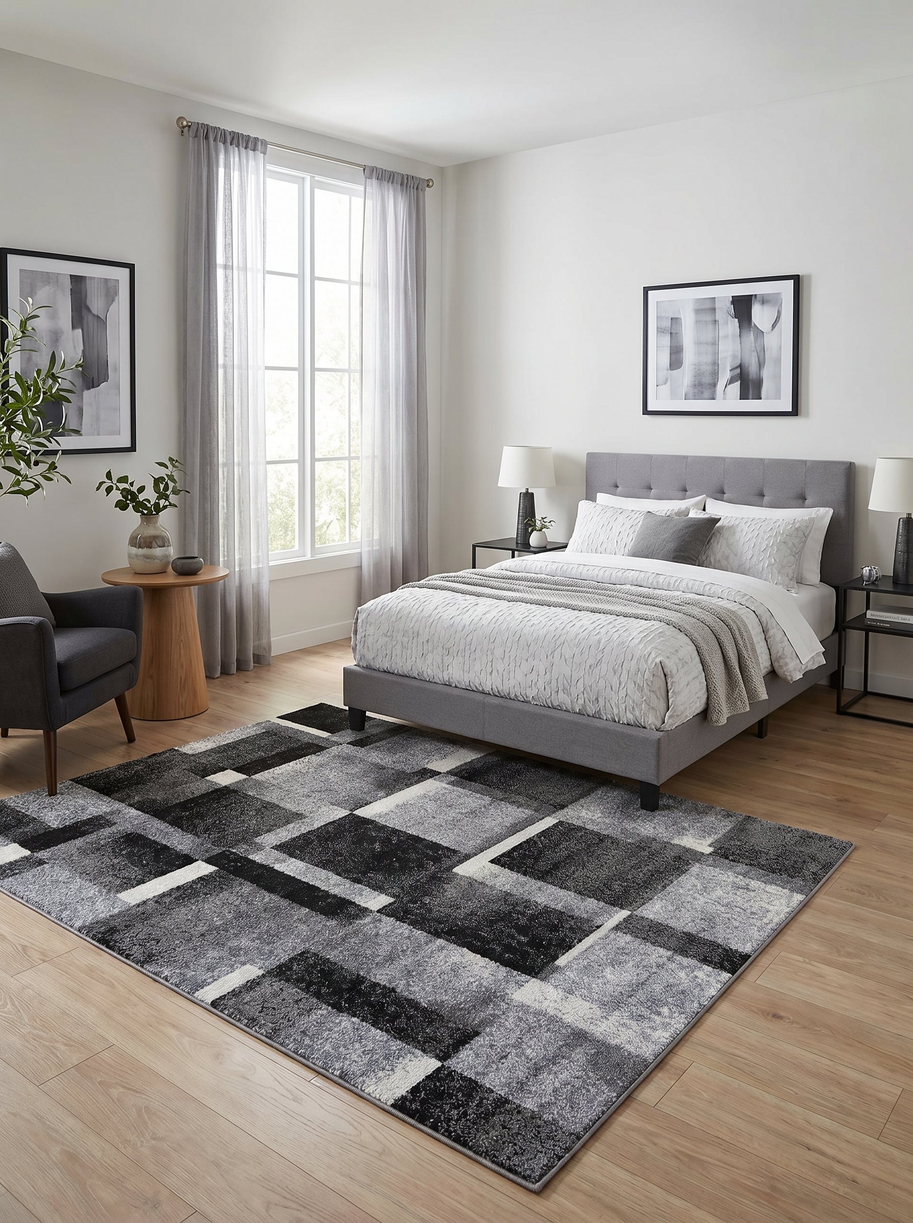 Tapis rectangulaire gris, noir et blanc, avec des motifs géométriques abstraits et texturés, posé dans une chambre moderne