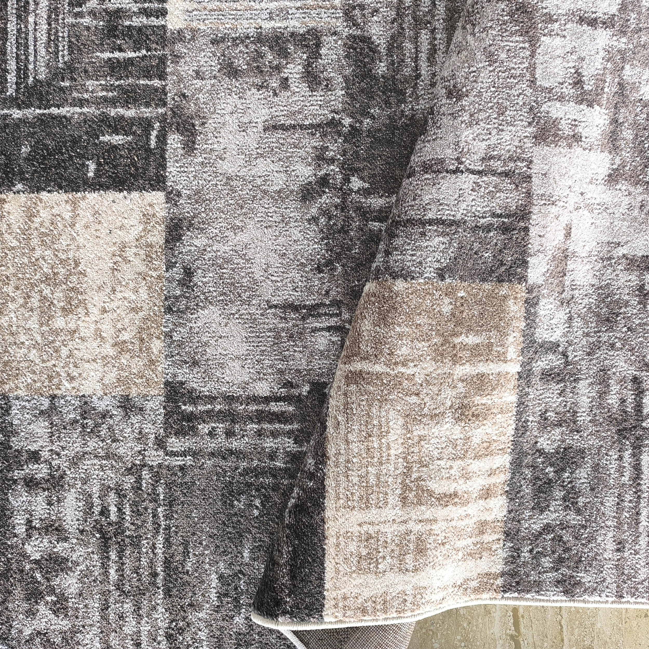 Tapis à poils longs et motifs fragmentés gris anthracite, gris clair et beige, légèrement plié