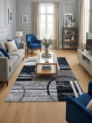 Tapis rectangulaire gris, noir et bleu marine, aux motifs abstraits géométriques avec des lignes et des arcs, dans un salon