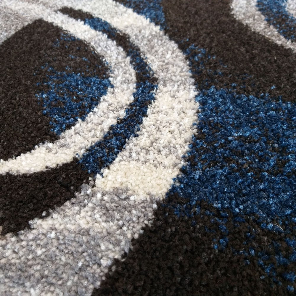 Tapis texturé aux motifs abstraits et ondulés en noir, bleu intense, gris et blanc