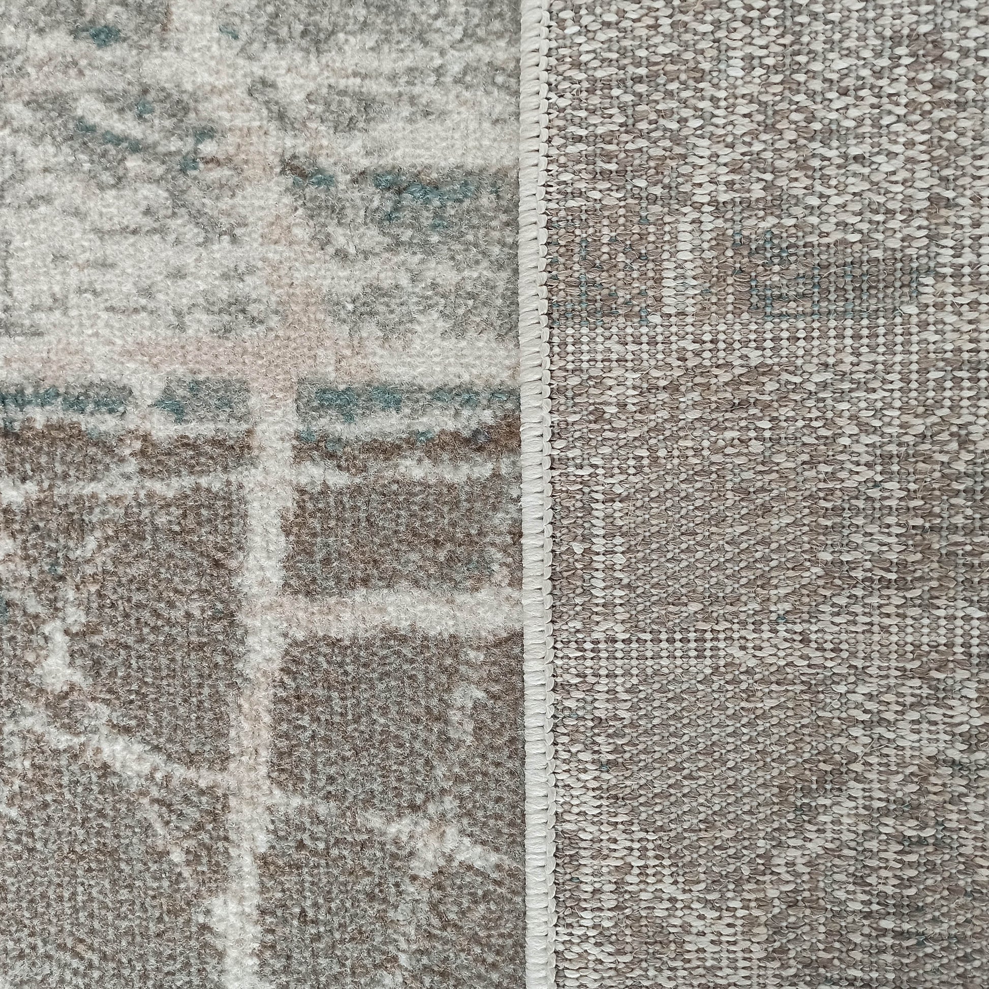 Tapis dont le dessus doux et texturé présente des motifs abstraits gris, blancs et bleus. Son envers est beige et tissé