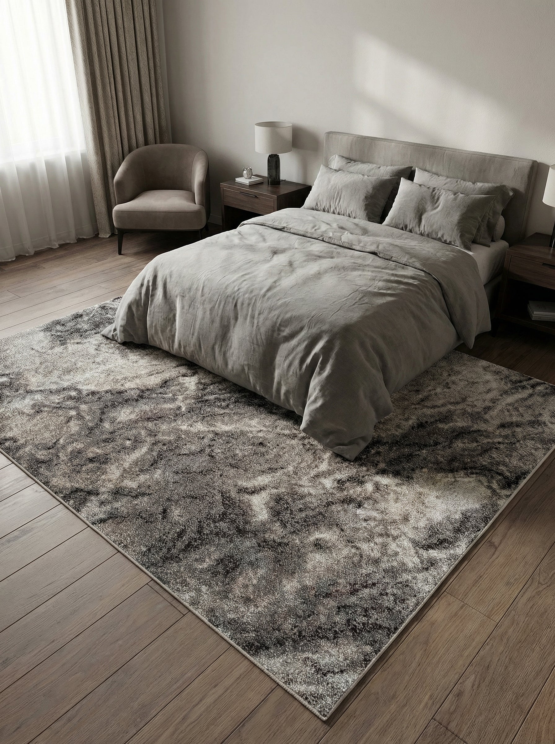 Tapis rectangulaire gris foncé et clair aux motifs abstraits, à texture variée, posé sur un parquet en bois dans une chambre moderne