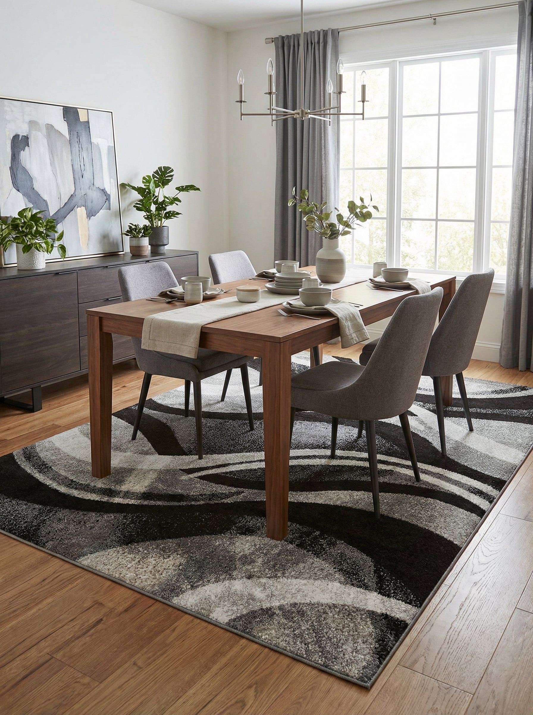 Tapis rectangulaire aux motifs abstraits et ondulés noir, gris et blanc sous une table en bois d'une salle à manger moderne