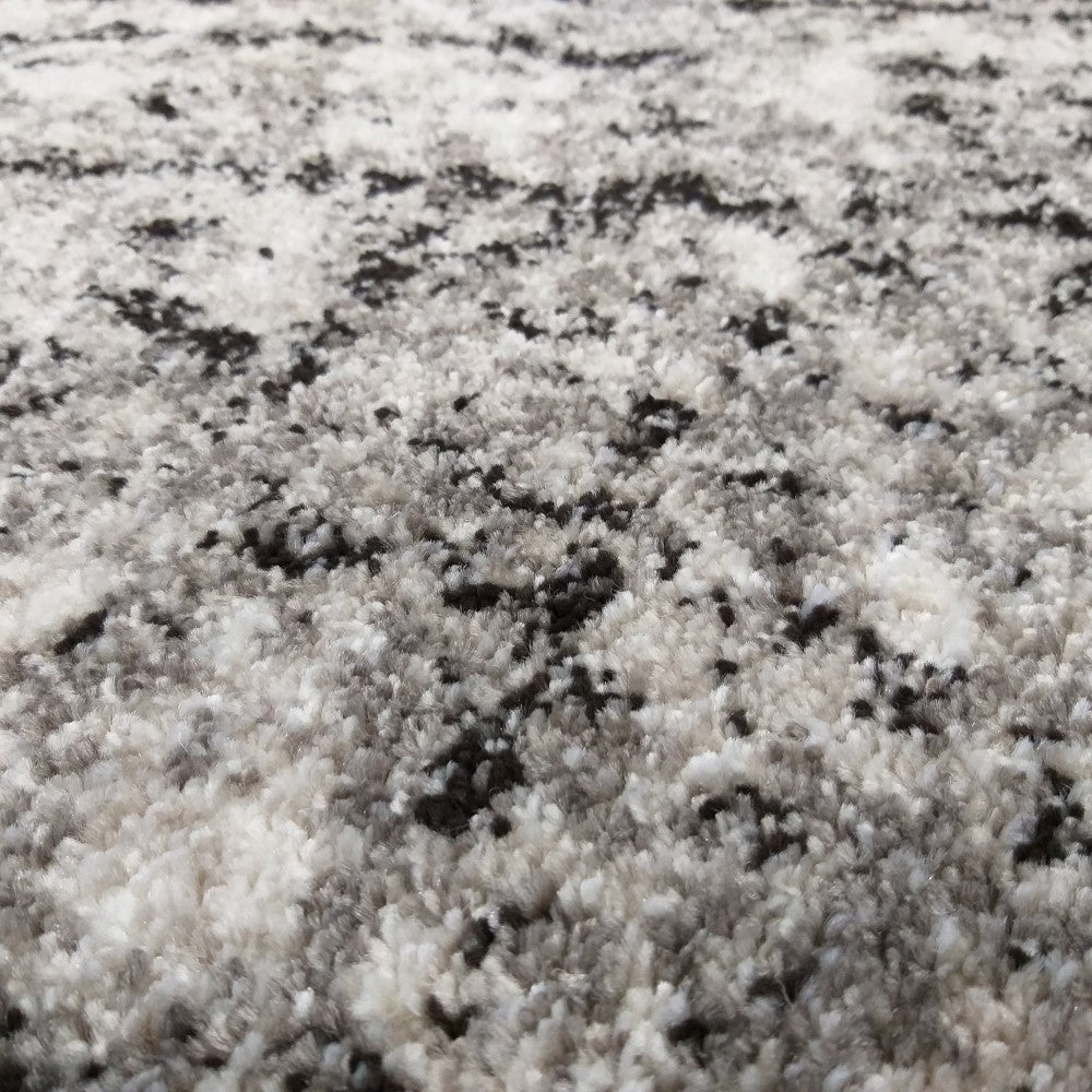 Tapis moelleux aux poils longs, blanc, gris et noir avec un motif abstrait et moucheté