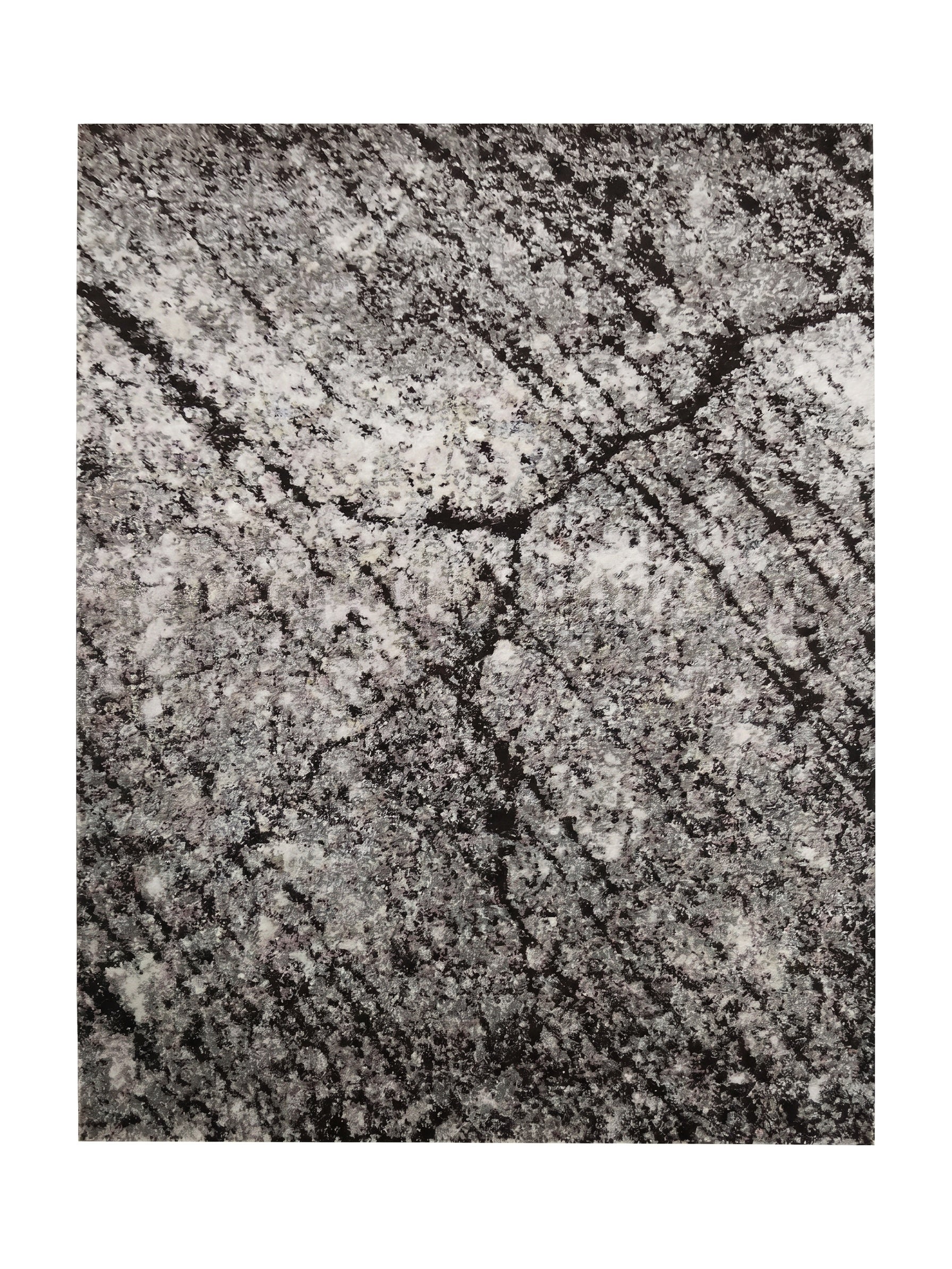 Tapis rectangulaire aux motifs abstraits et irréguliers mêlant le noir, le blanc et le gris clair, avec une texture douce