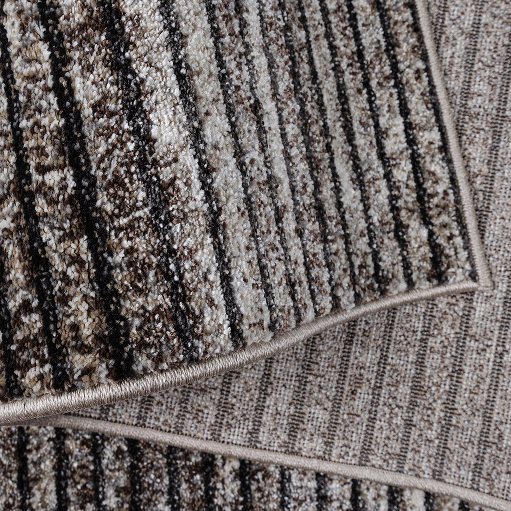 Tapis à rayures verticales mêlant des textures de poils clairs et foncés, dans des nuances de beige, crème et marron