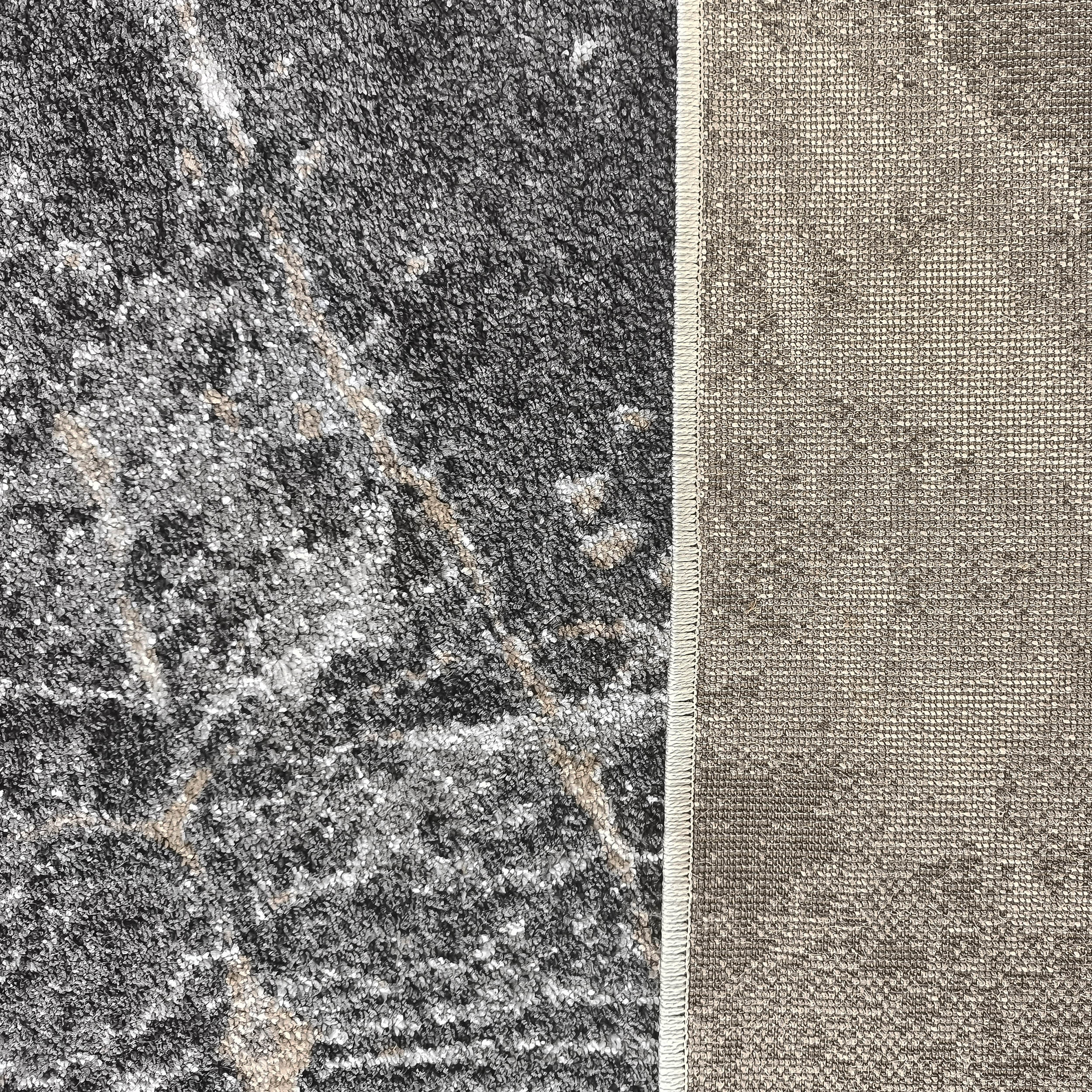 Tapis à poils courts gris anthracite avec des motifs marbrés clairs et un dos en tissu tissé beige sur le côté droit