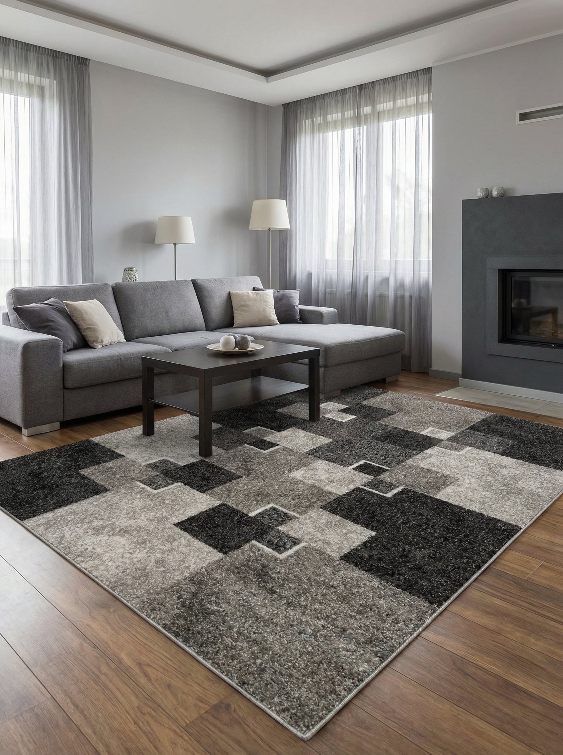 Tapis shaggy rectangulaire à motifs géométriques noirs, gris anthracite et gris clair, dans un salon moderne