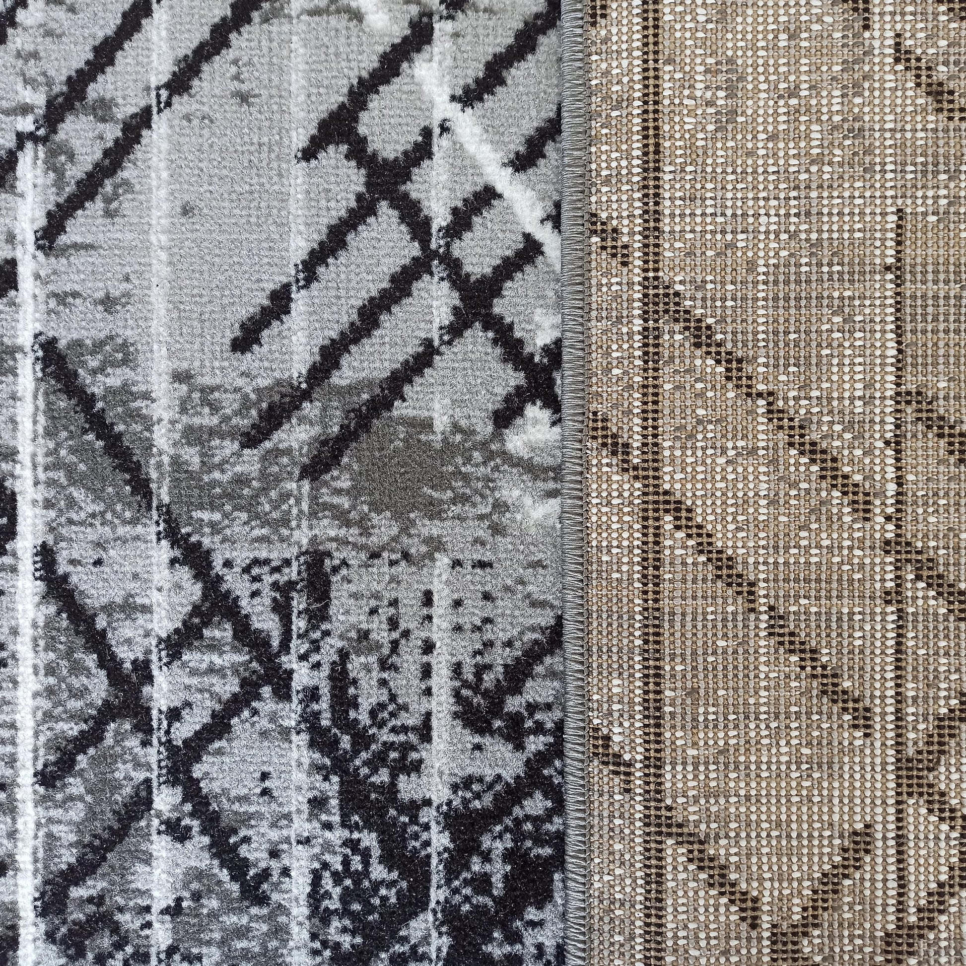 Tapis avec le dessus en texture douce gris, noir et blanc à motifs abstraits et le dos tissé beige et noir