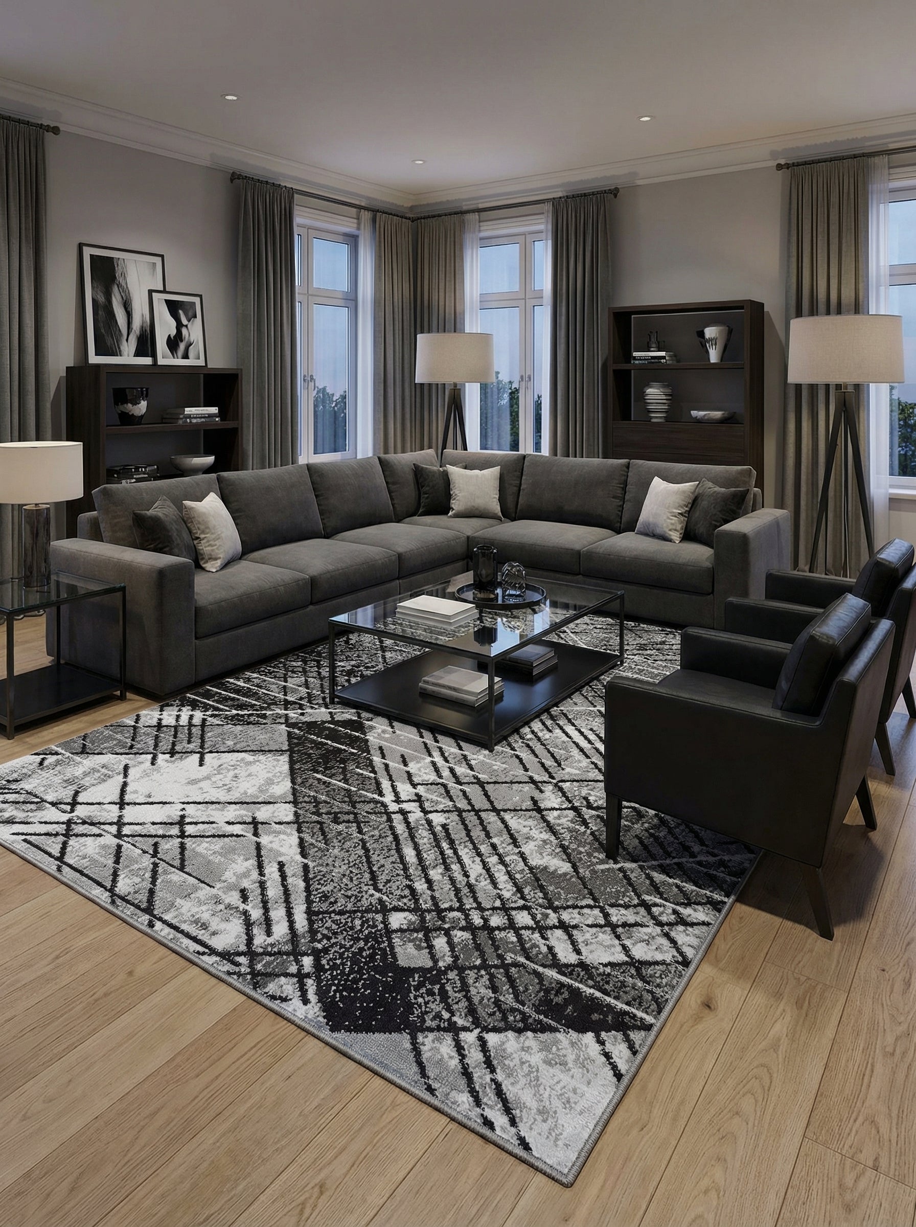 Tapis rectangulaire à motifs géométriques abstraits noirs, gris et blancs, posé sur un parquet clair dans un salon moderne