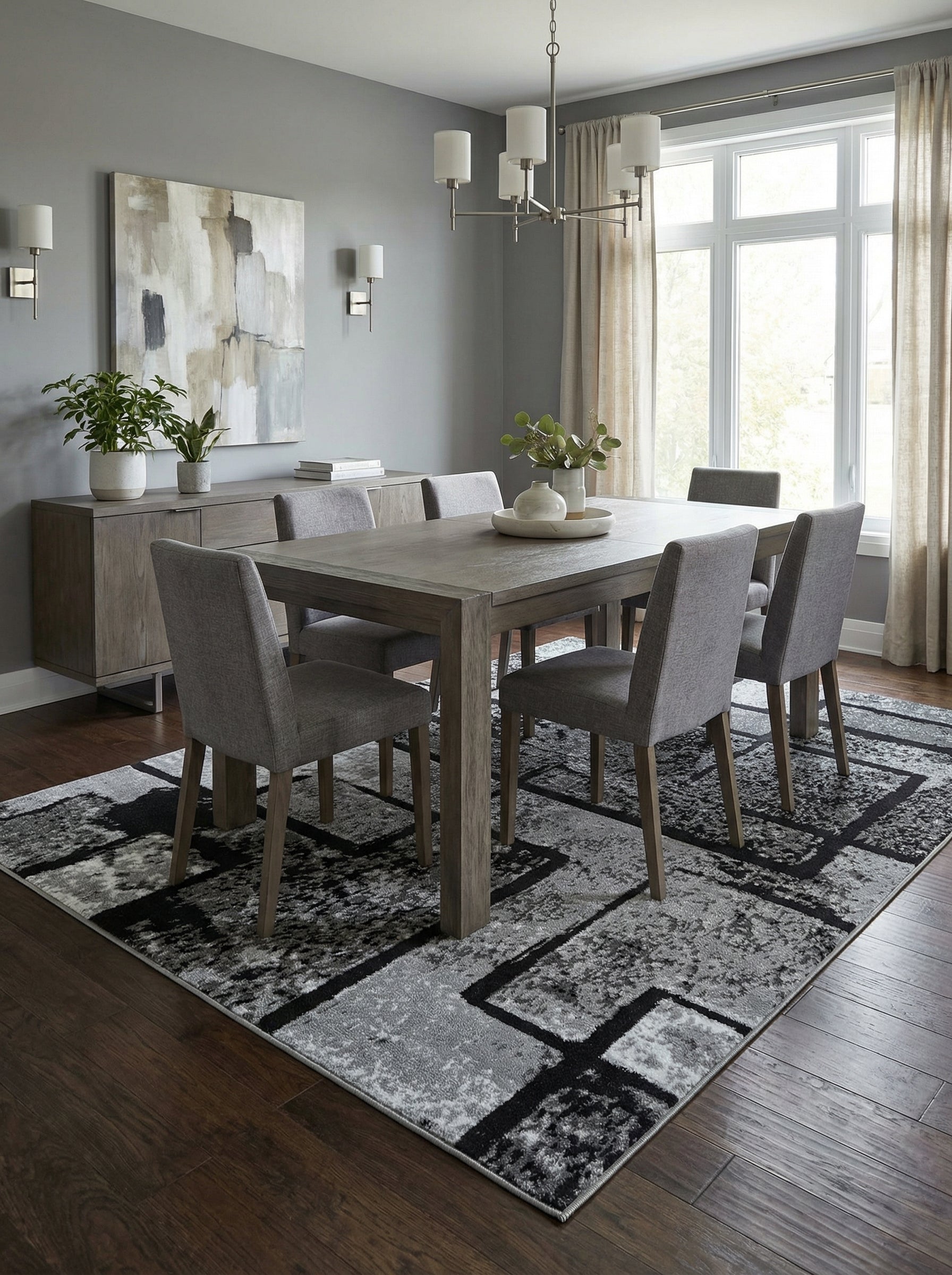 Tapis rectangulaire gris, noir et blanc aux motifs géométriques abstraits et texturés, dans une salle à manger élégante