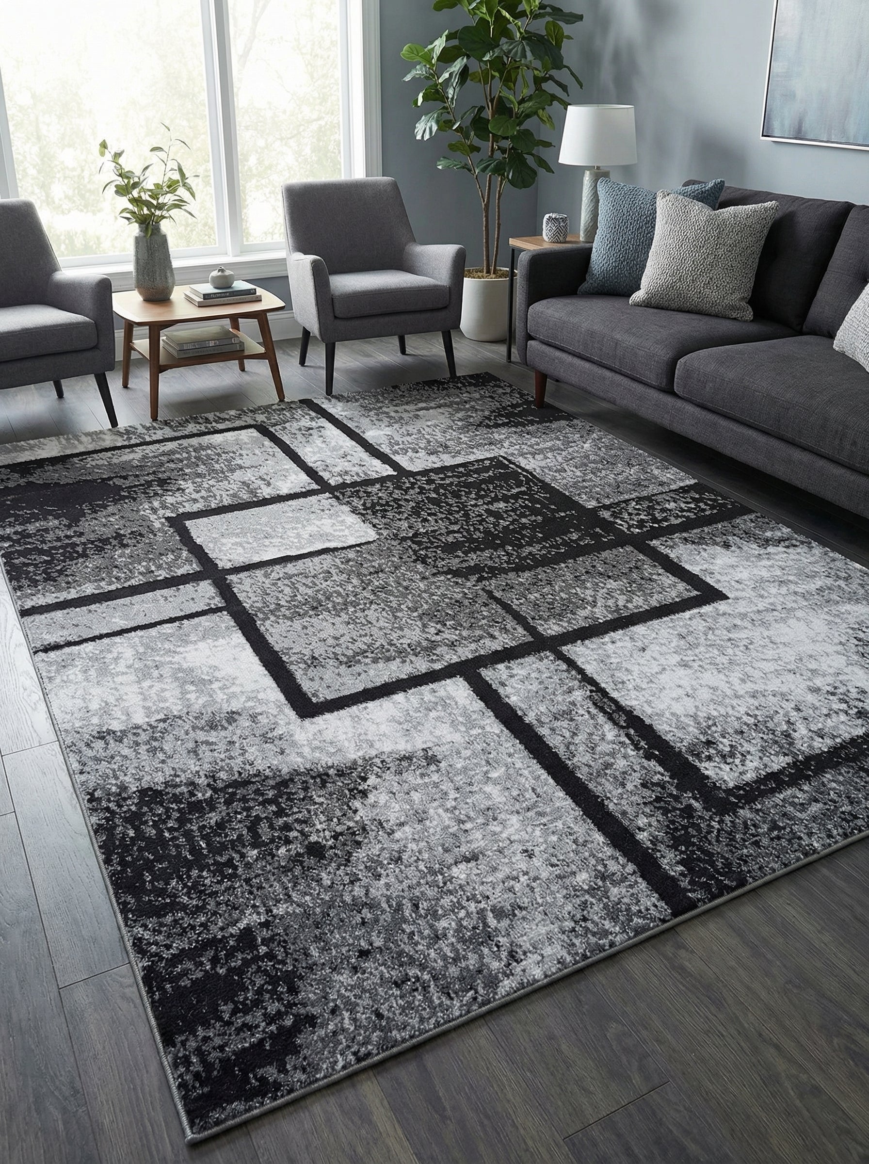 Tapis rectangulaire abstrait noir, gris et blanc à motifs géométriques, posé sur un parquet foncé dans un salon moderne
