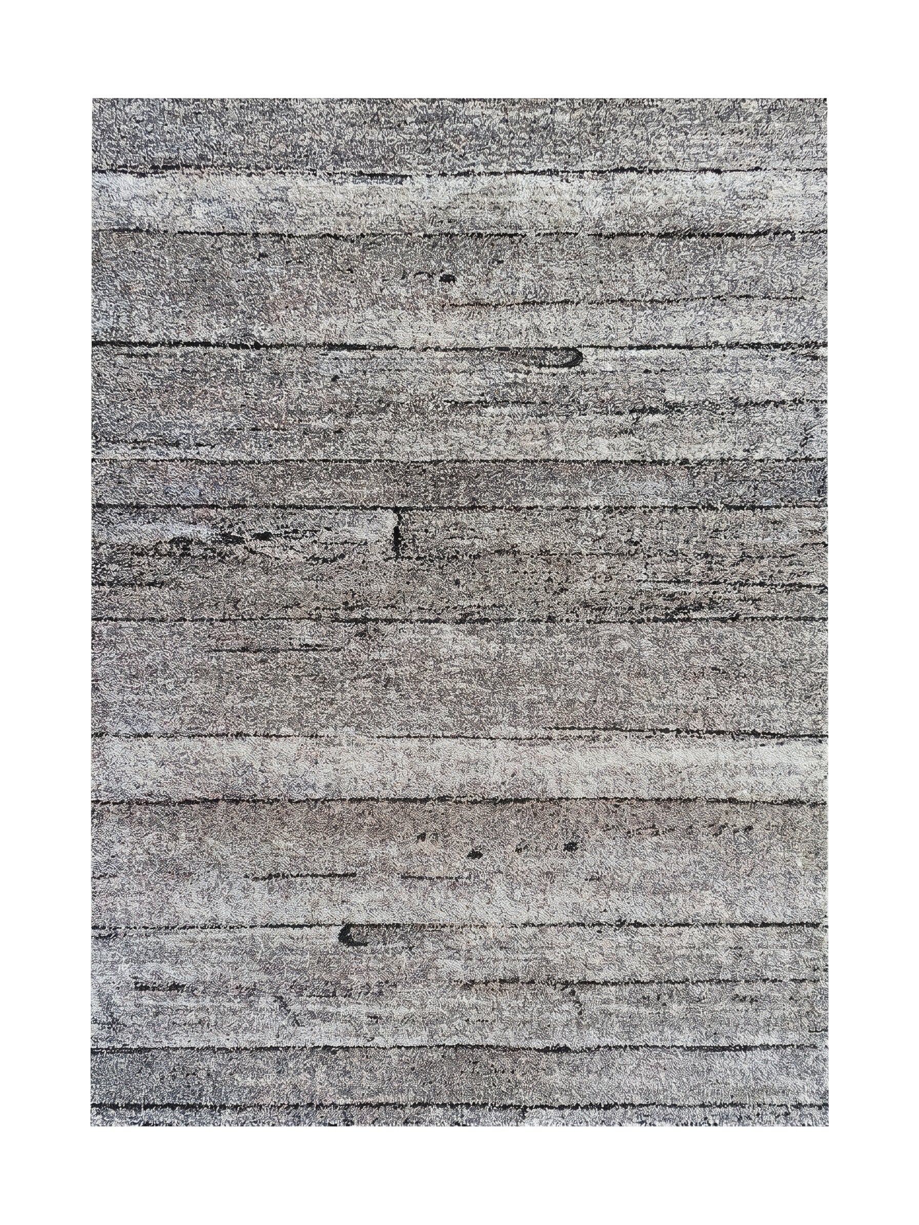 Tapis aux teintes de gris, noir et blanc, présentant un motif texturé de bandes horizontales irrégulières, rappelant le grain du bois vieilli