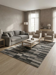 Tapis rectangulaire texturé aux motifs géométriques à bandes déstructurées gris, noirs et blancs, dans un salon lumineux
