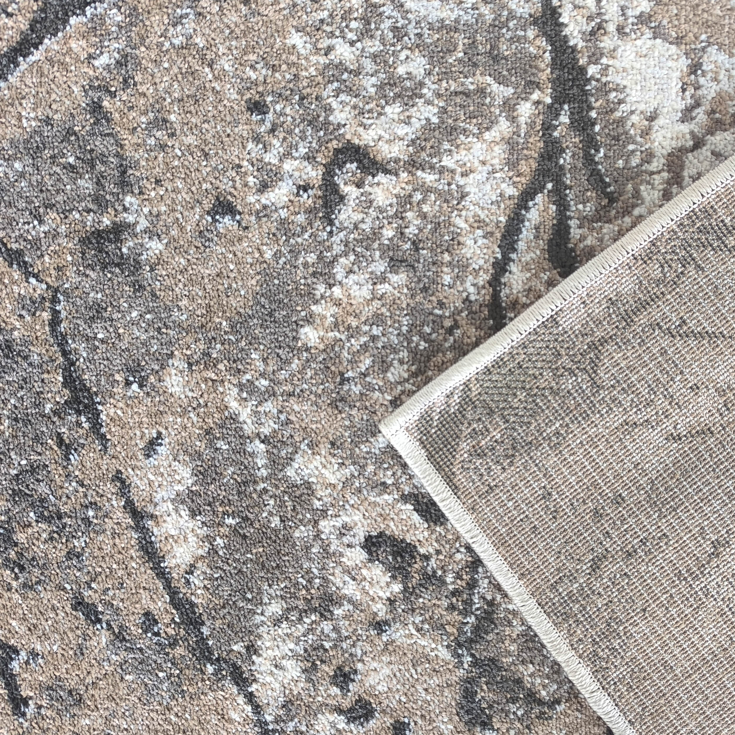 Tapis à texture bouclée et motifs abstraits marron, gris et blanc avec un coin replié révélant l'envers tissé