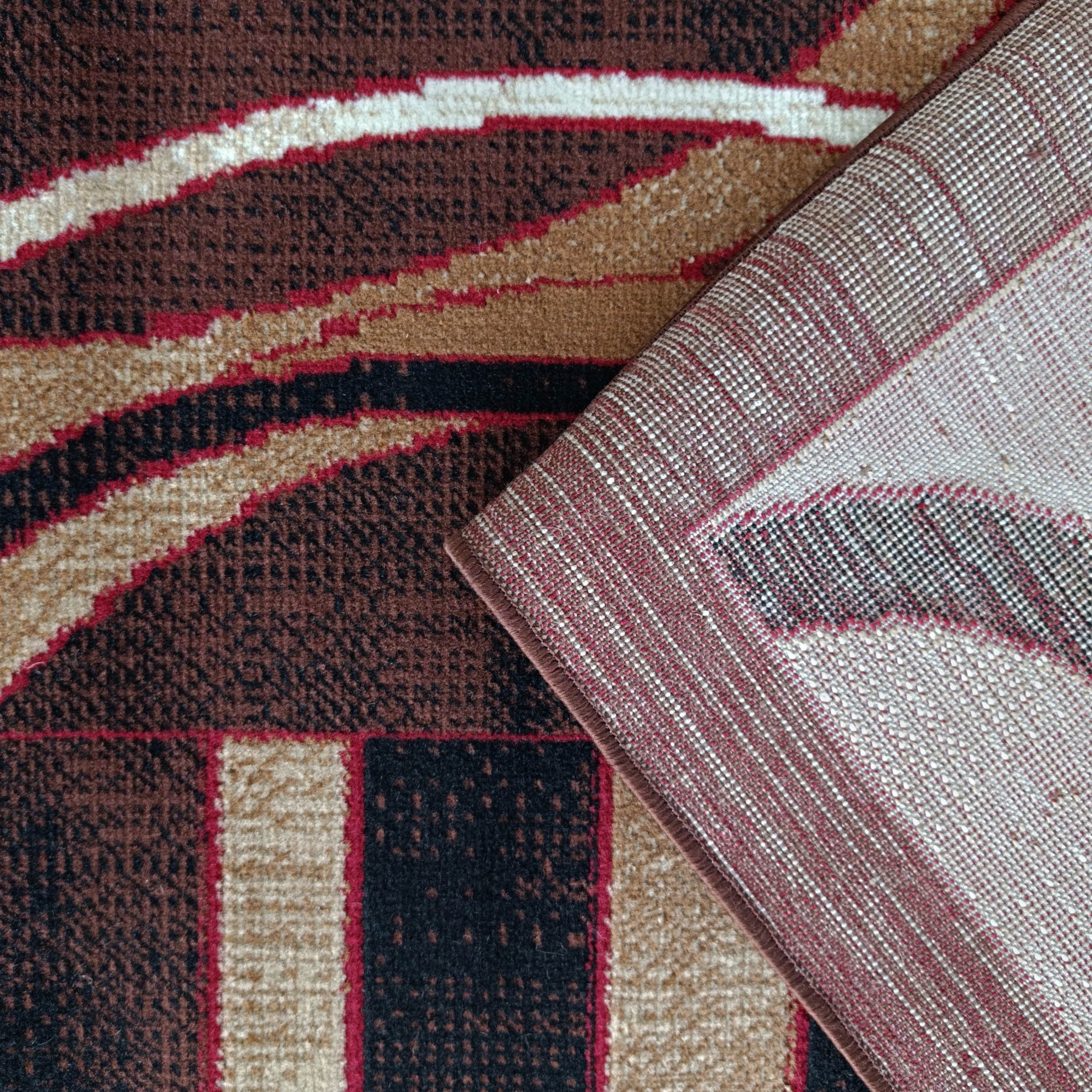 Tapis marron à motifs abstraits beiges, rouges, noirs, un coin relevé révèle le revers tissé à carreaux clairs-rouges