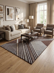 Tapis rectangulaire à poils mi-longs, motifs géométriques marron, beige et gris, alternant bandes et blocs, dans un salon lumineux