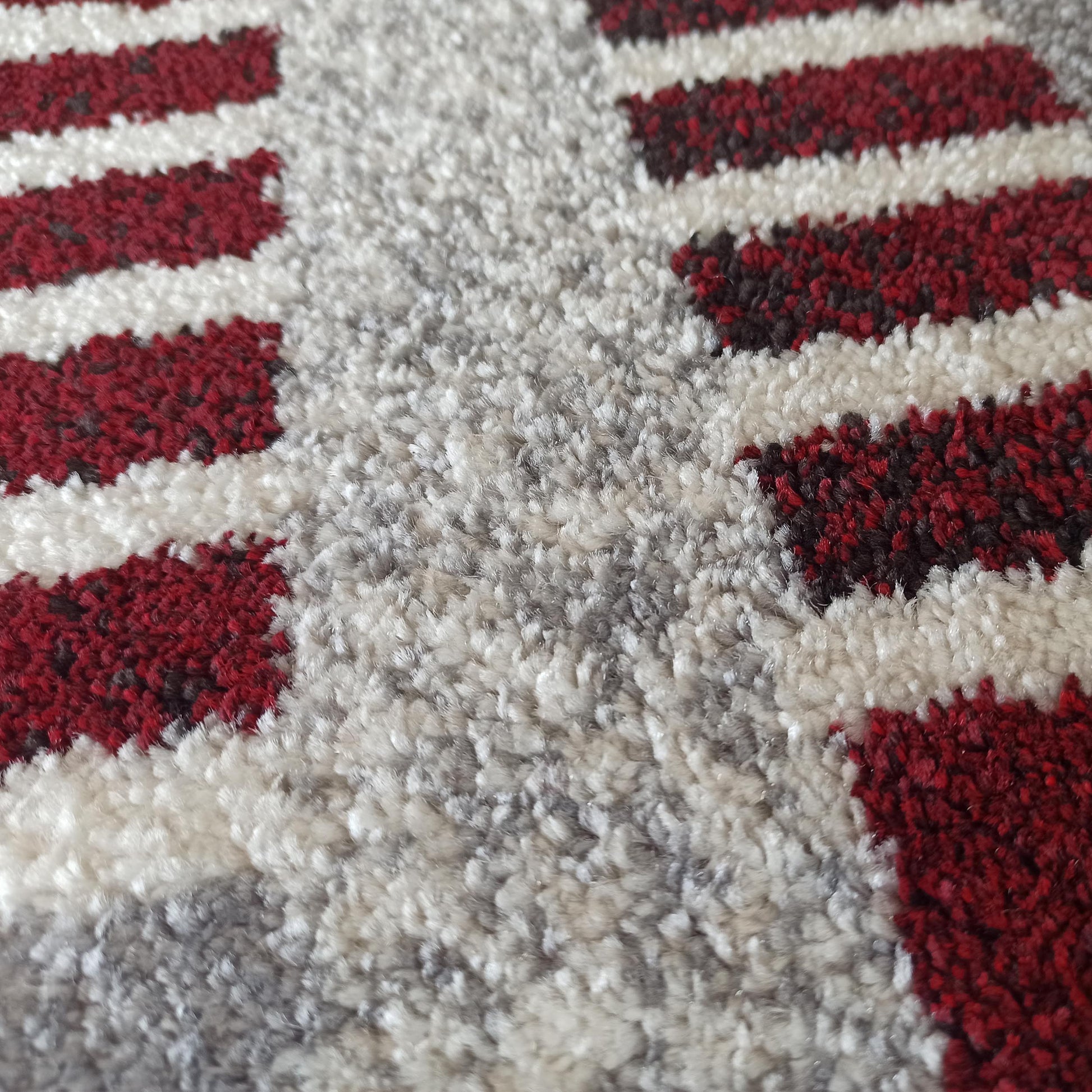 Tapis à poils longs avec un motif de larges bandes rouge bordeaux, blanc cassé et gris chiné