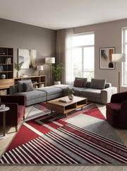 Tapis rectangulaire à motifs géométriques rouge, gris et blanc avec des blocs de couleur et des rayures diagonales, dans un salon