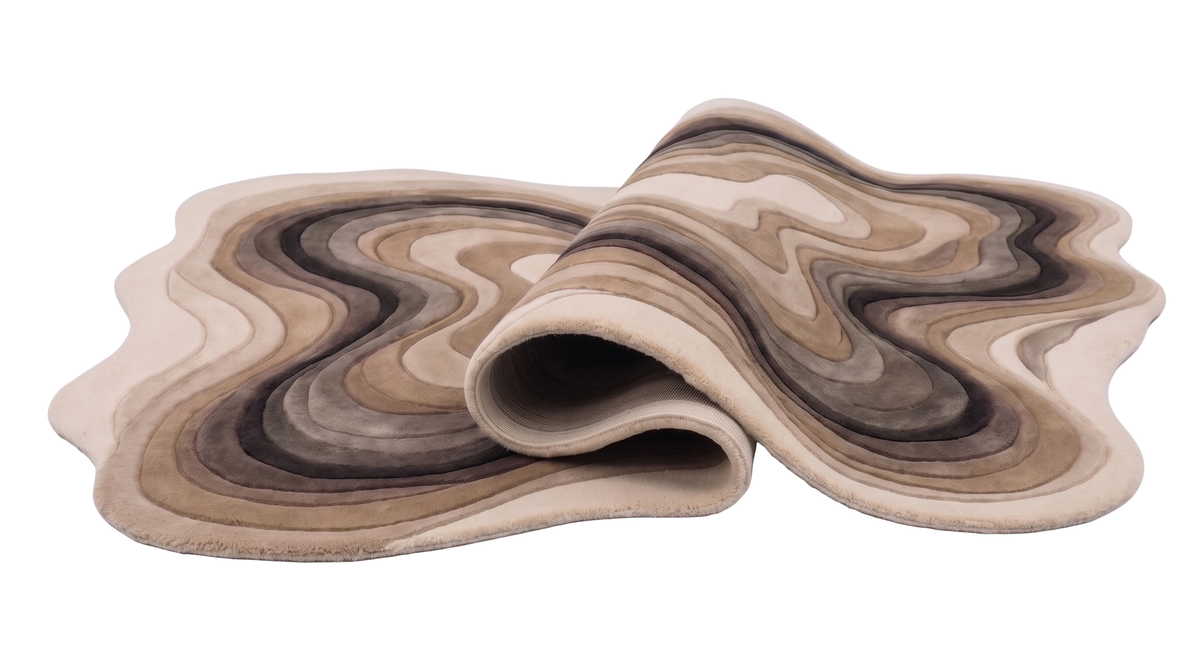 La laine sculptée beige et brune de ce tapis organique se dévoile en relief et épaisseur sur sa partie roulée
