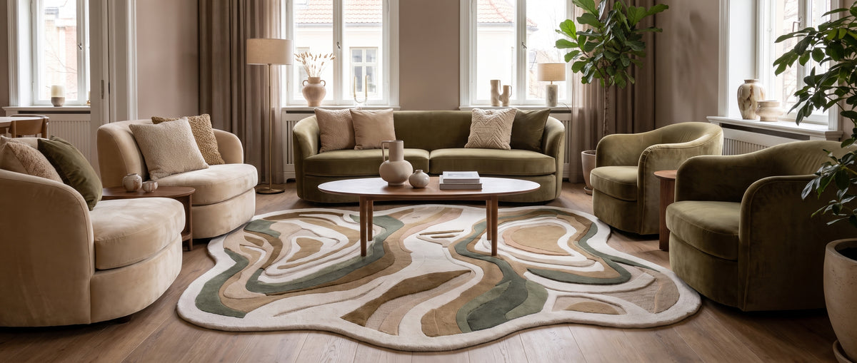 Tapis en laine sculptée, de forme irrégulière, aux motifs organiques fluides beige, taupe et vert sauge dans un salon