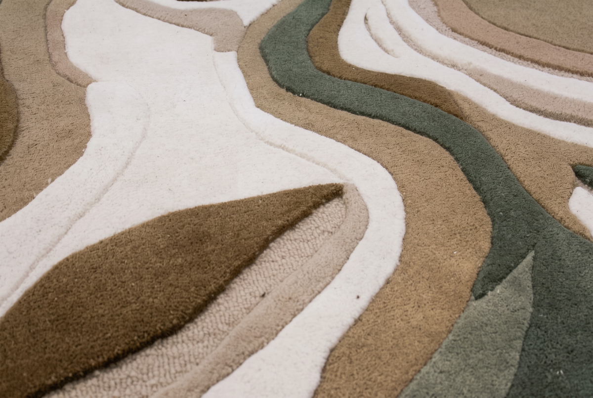 Relief détaillé de la laine beige, taupe et vert sauge, avec des zones de poils coupés et de boucles