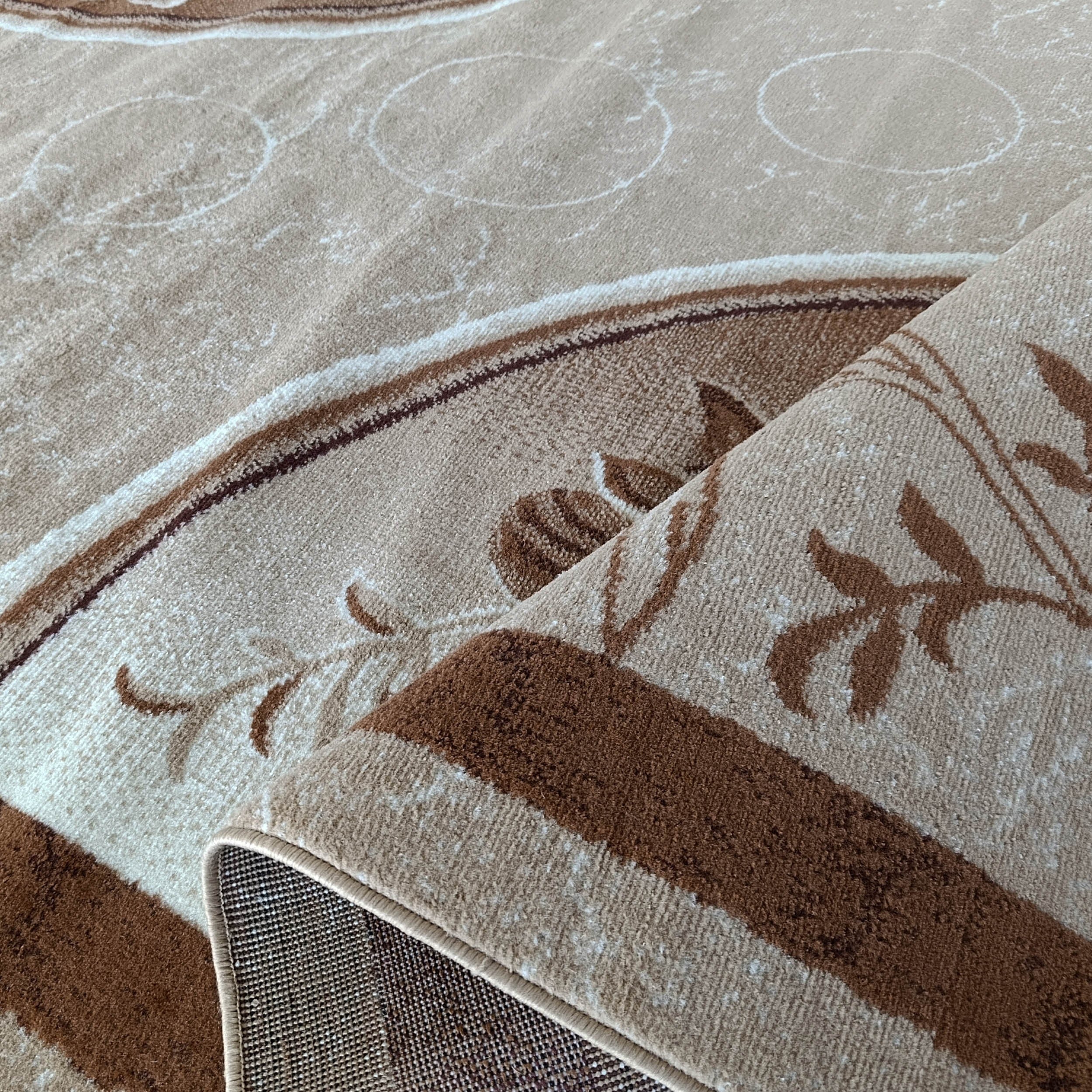 Tapis beige enroulé, révélant des motifs floraux marron, des bandes foncées et de discrets cercles sur sa surface visible