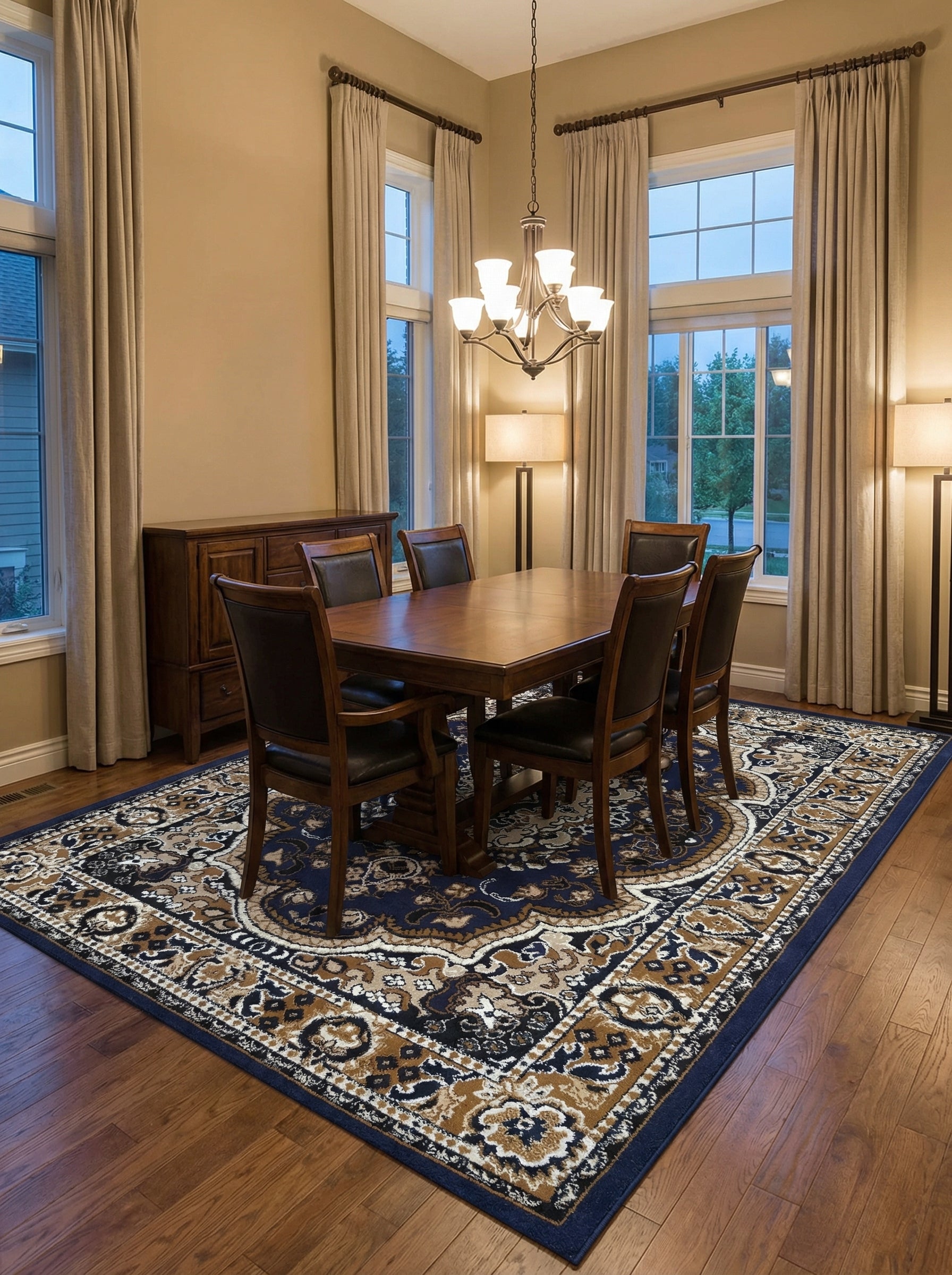 Tapis rectangulaire à motifs floraux baroques bleu marine, beige, noir et crème, sous une table en bois dans une salle à manger élégante