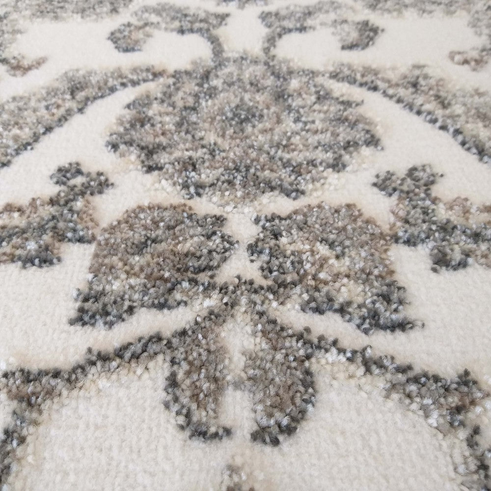 Tapis crème à motif floral ornemental en relief, chiné gris et marron, à la texture douce et dense