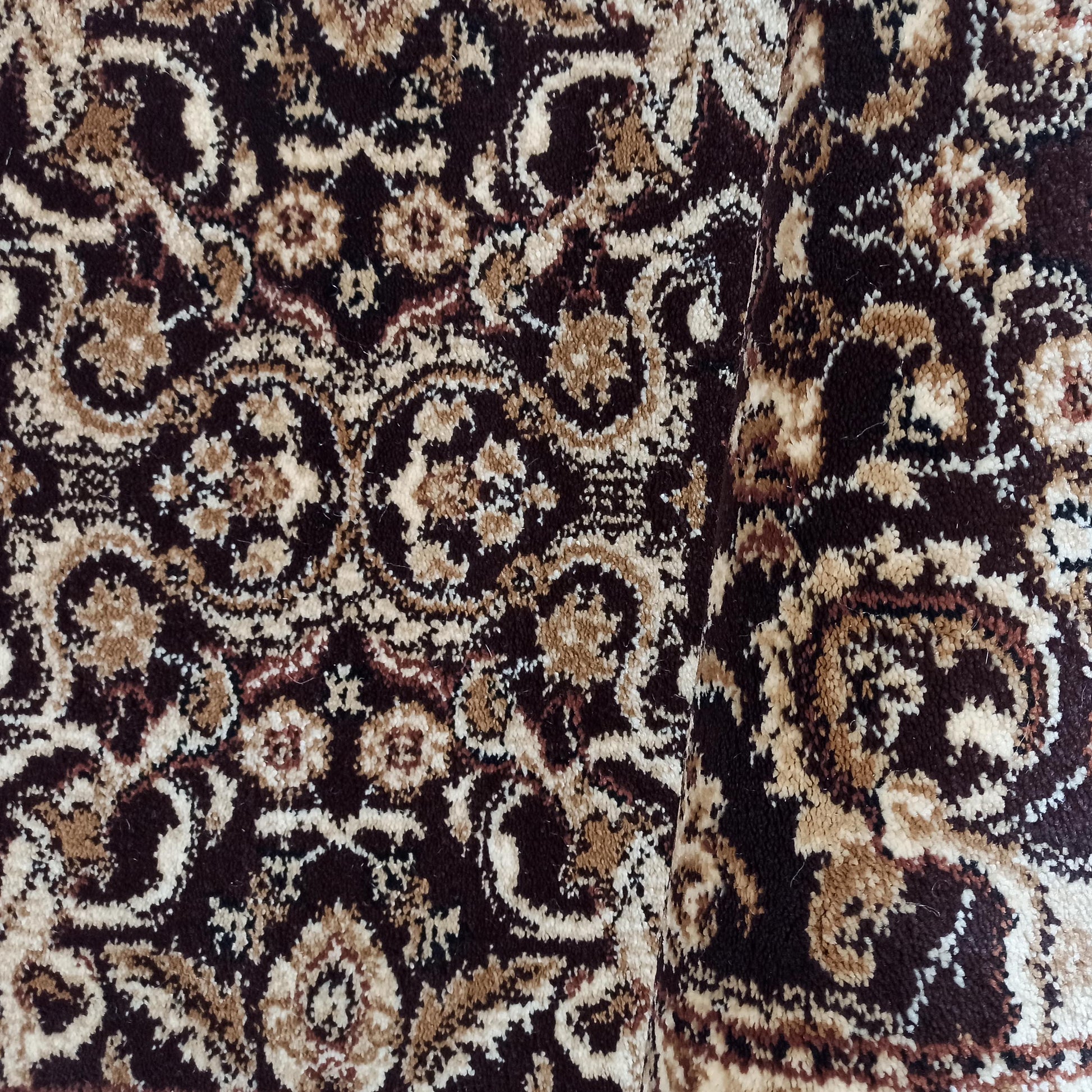 Tapis en textile tissé orné de motifs arabesques complexes en marron foncé, beige, crème et quelques touches de rouge-brun