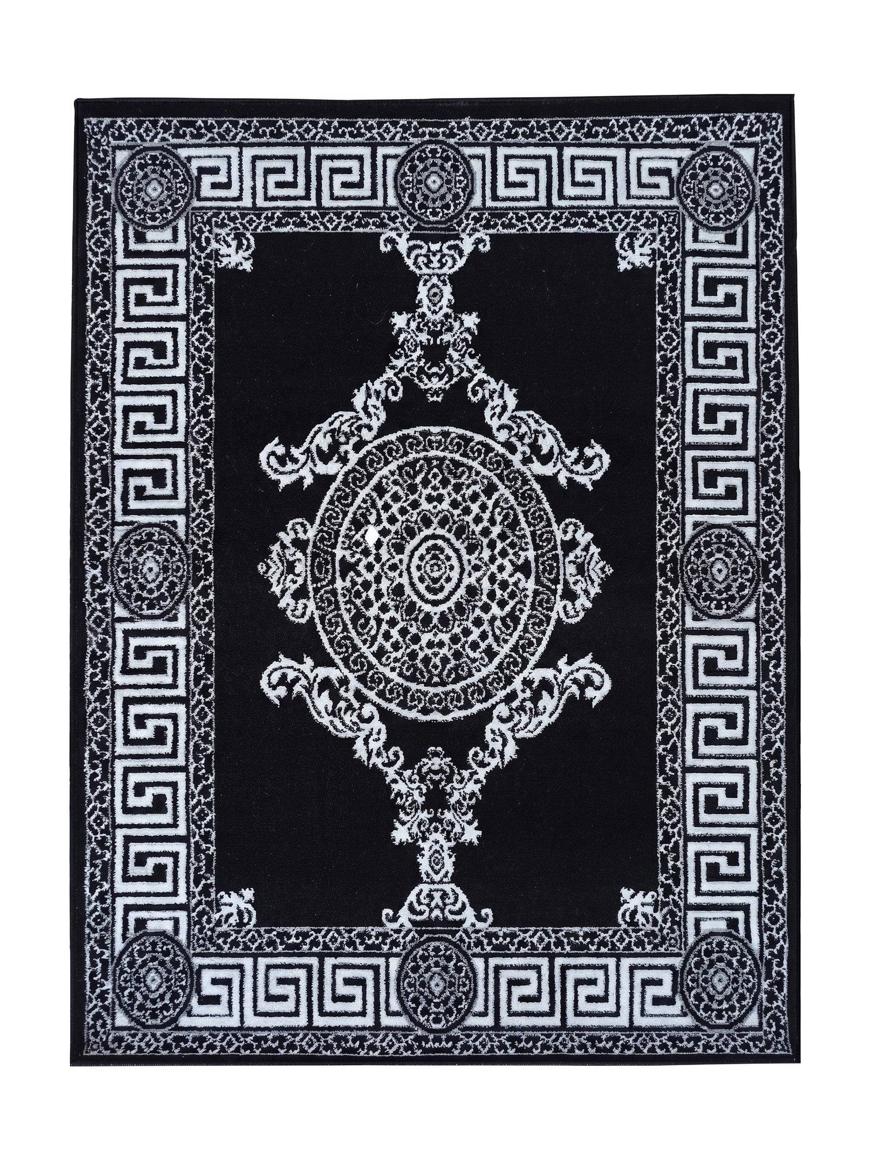 Tapis rectangulaire noir avec des motifs ornementaux blancs. Une frise en méandre grec encadre un médaillon central et des volutes