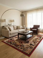Tapis rectangulaire beige avec motifs floraux rouges, noirs et bruns et bordure rouge vif, posé dans un salon moderne