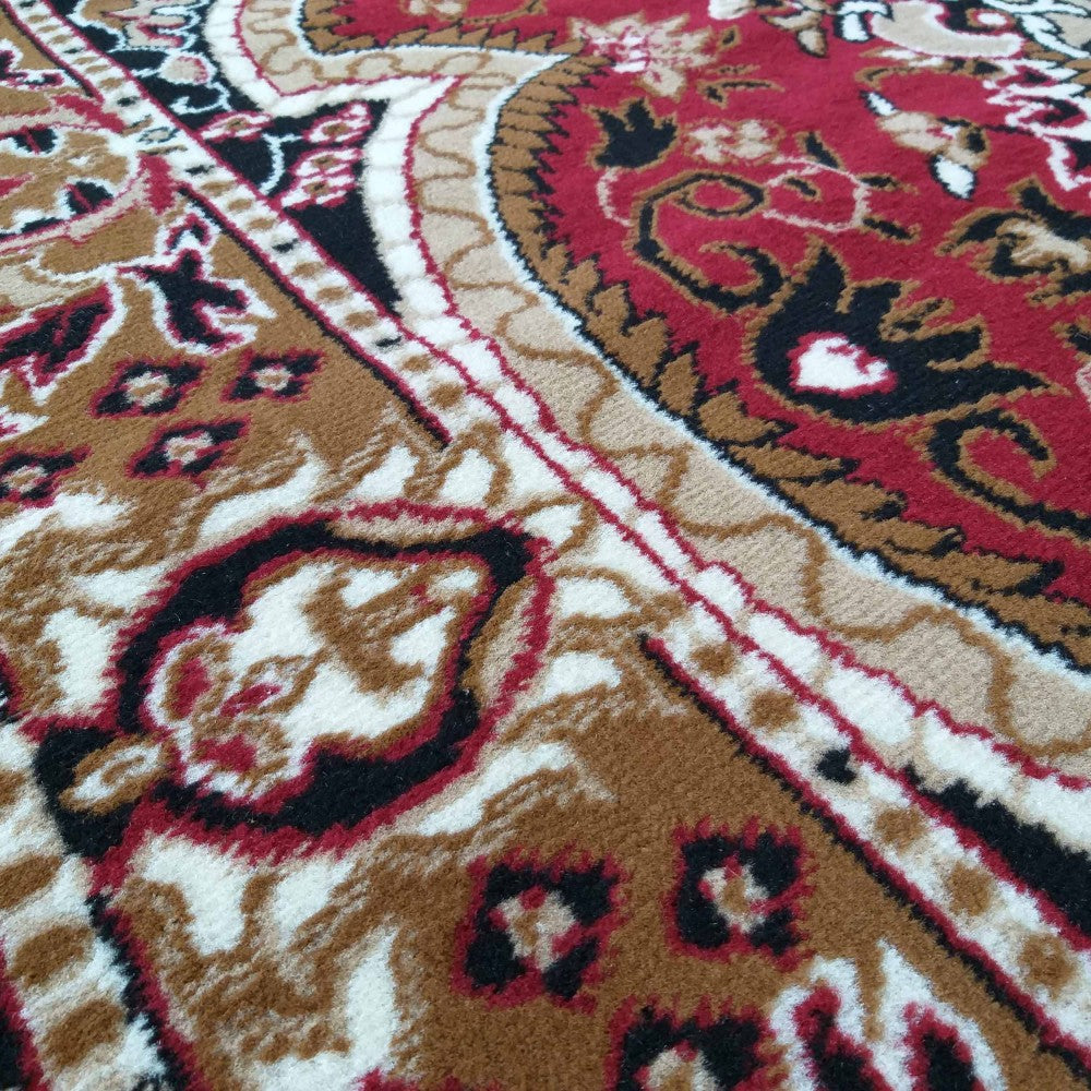 Tapis à motifs orientaux complexes rouge, brun, noir et crème, avec une texture de fibres douces clairement visible