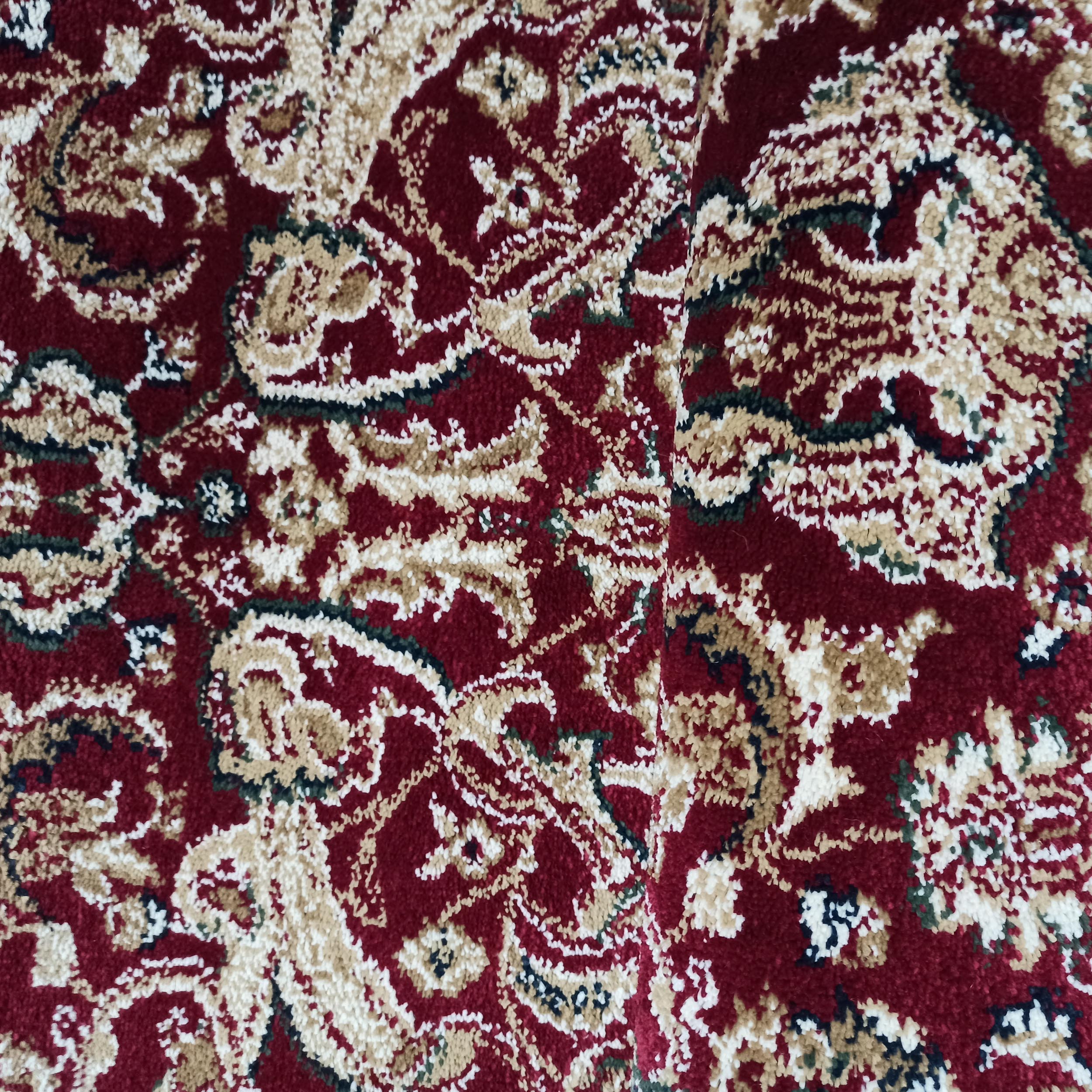 Tapis rouge foncé texturé à motifs complexes et entrelacés de couleur crème, ocre, vert forêt et bleu nuit