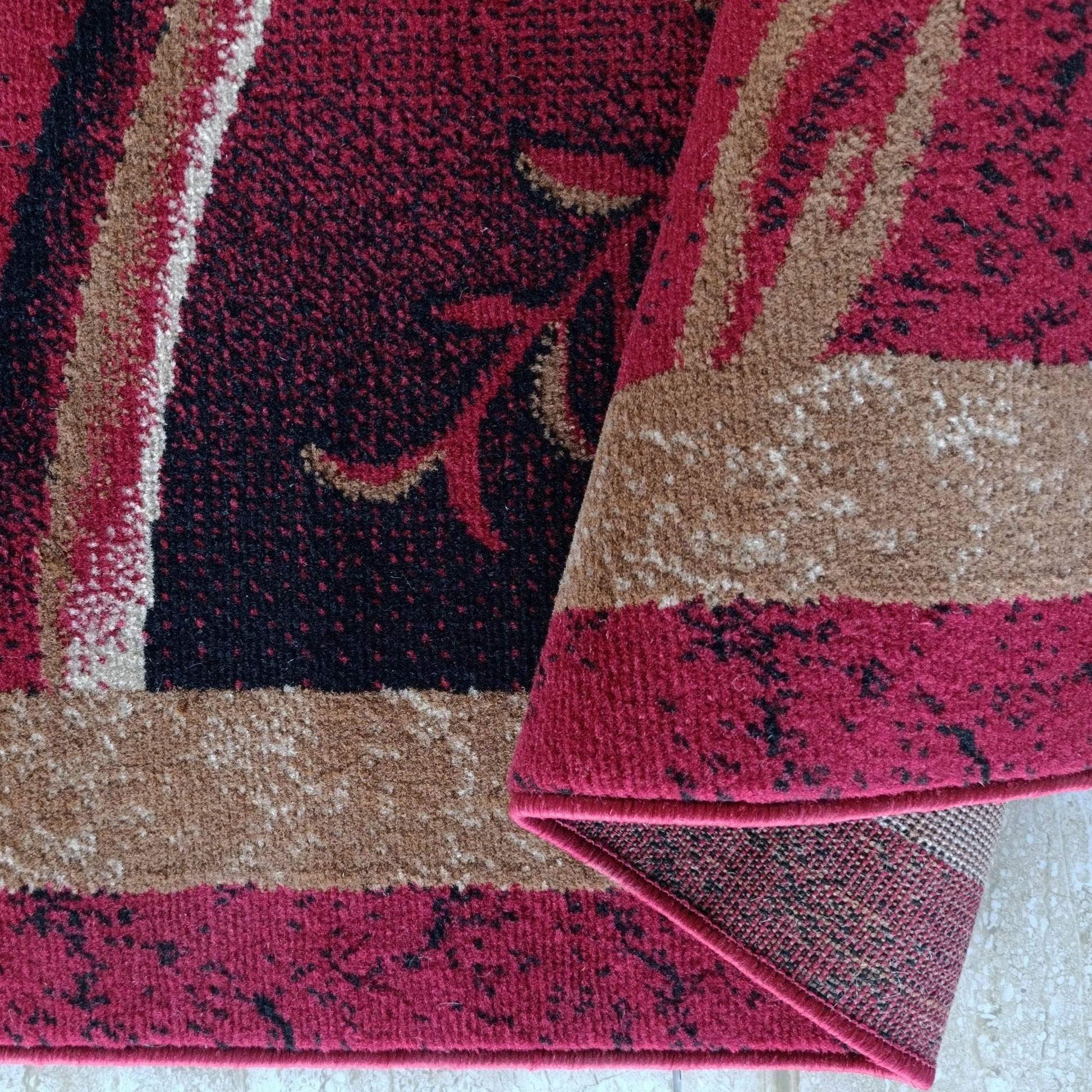Tapis roulé avec des motifs abstraits rouge bordeaux, noirs et beiges. La texture de la moquette est à poils courts et denses