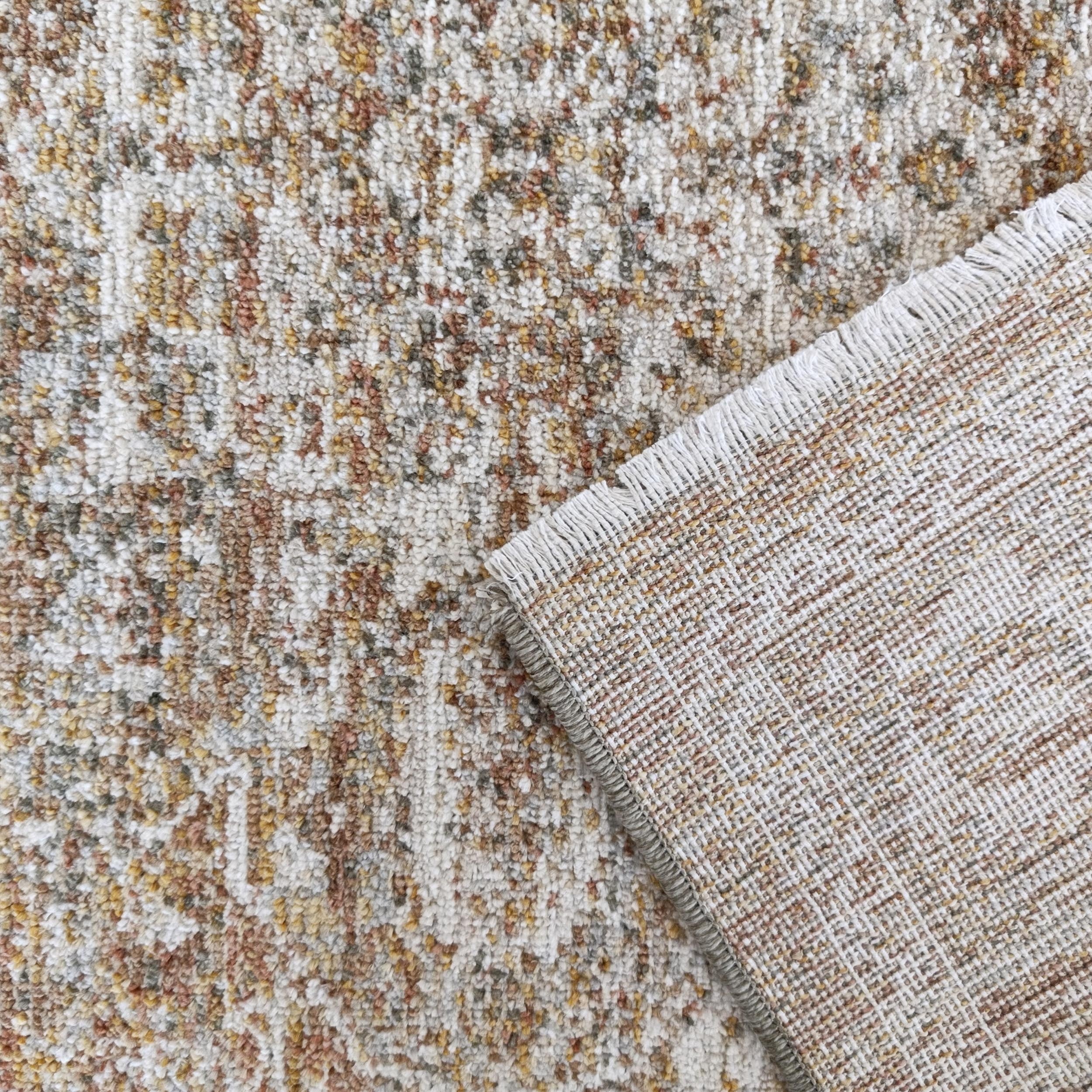 Tapis texturé aux motifs mouchetés crème, marron et ocre, avec son envers tissé aux motifs quadrillés apparents