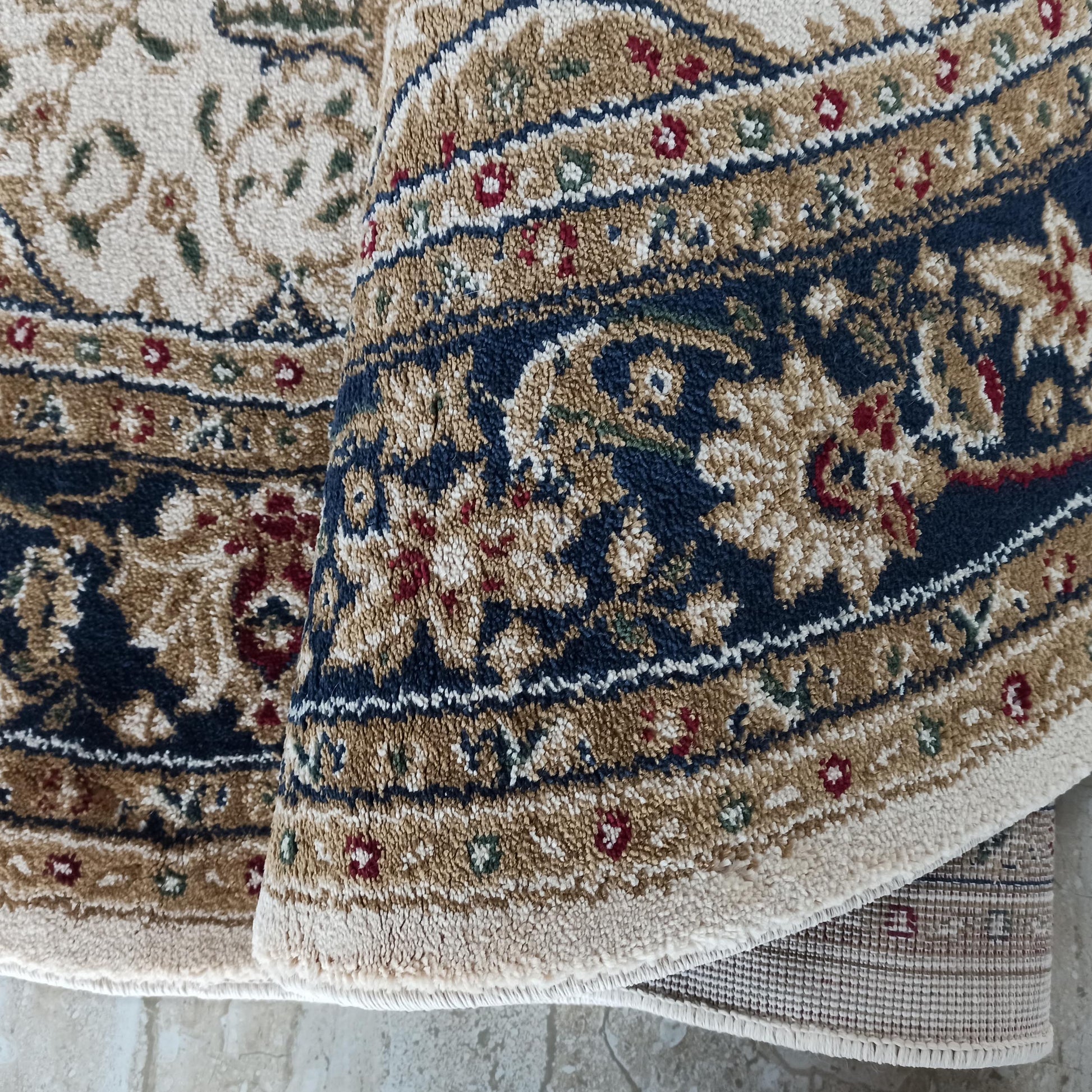 Tapis moelleux aux motifs floraux et arabesques, teinté de crème, beige, bleu marine, rouge et vert