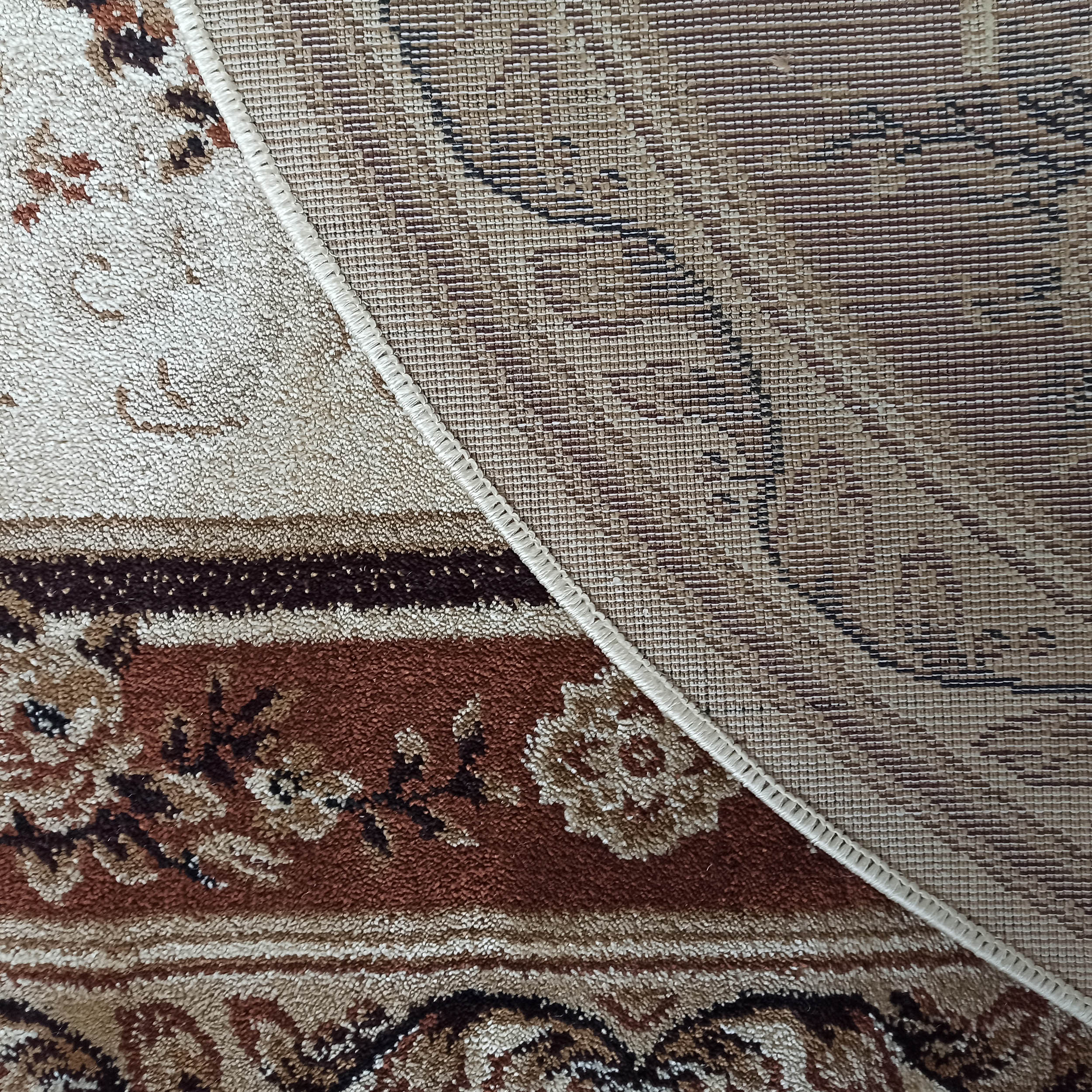 Tapis aux motifs floraux beiges et marron, présentant une partie du dessus moelleux et du revers tissé