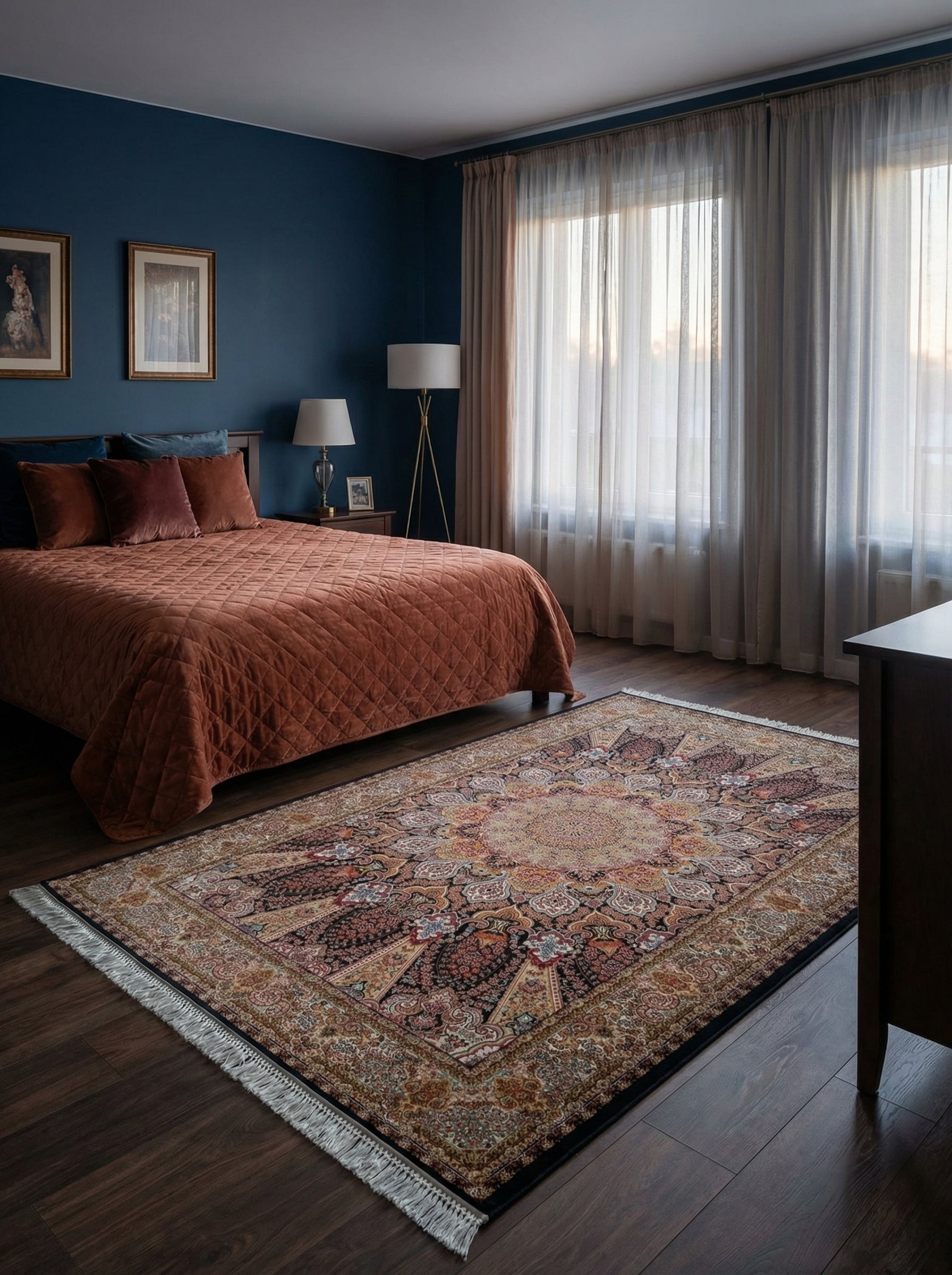 Tapis rectangulaire d'inspiration persane aux motifs floraux et médaillon complexes en teintes de noir, bordeaux, ocre et bleu, avec franges, au sol d'une chambre