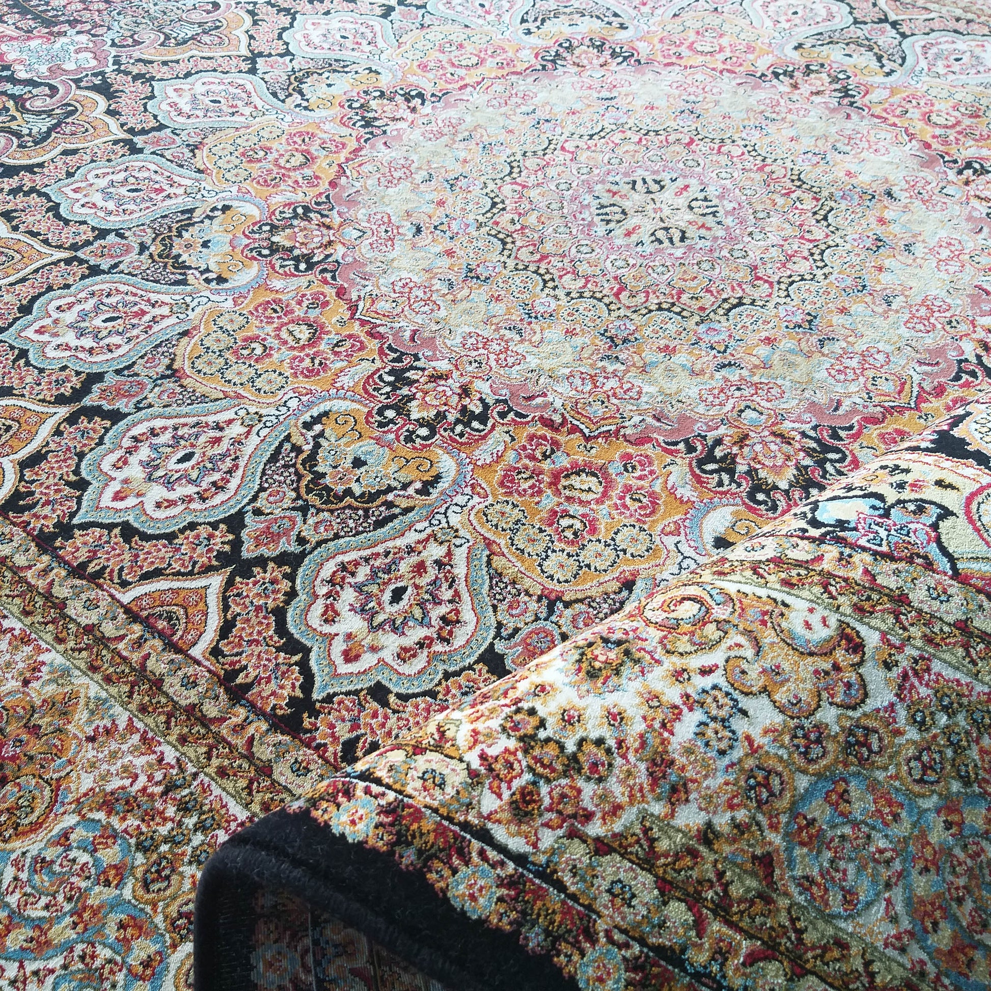 Tapis textile aux motifs persans traditionnels cachemire et floraux, avec des teintes de rouge, bleu, crème, doré et noir