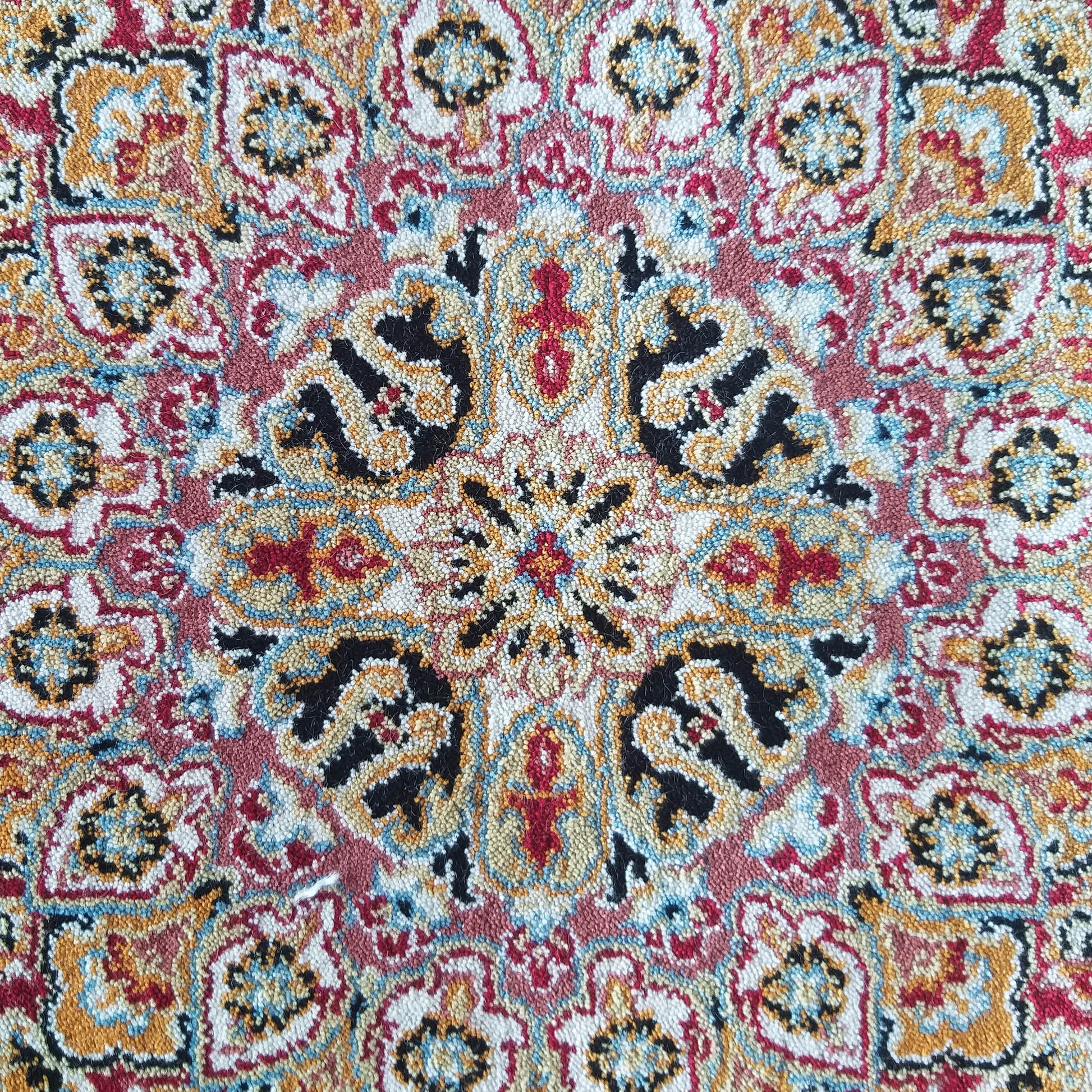 Tapis texturé aux motifs orientaux complexes et colorés en rouge, or, noir, bleu clair et crème
